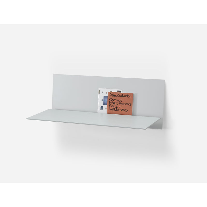 The S1 CHAPTER Bureau by Loehr is a wall-mounted, minimalist piece with a matte finish. It elegantly holds two books upright against its back panel, featuring clean lines for a functional and modern design.