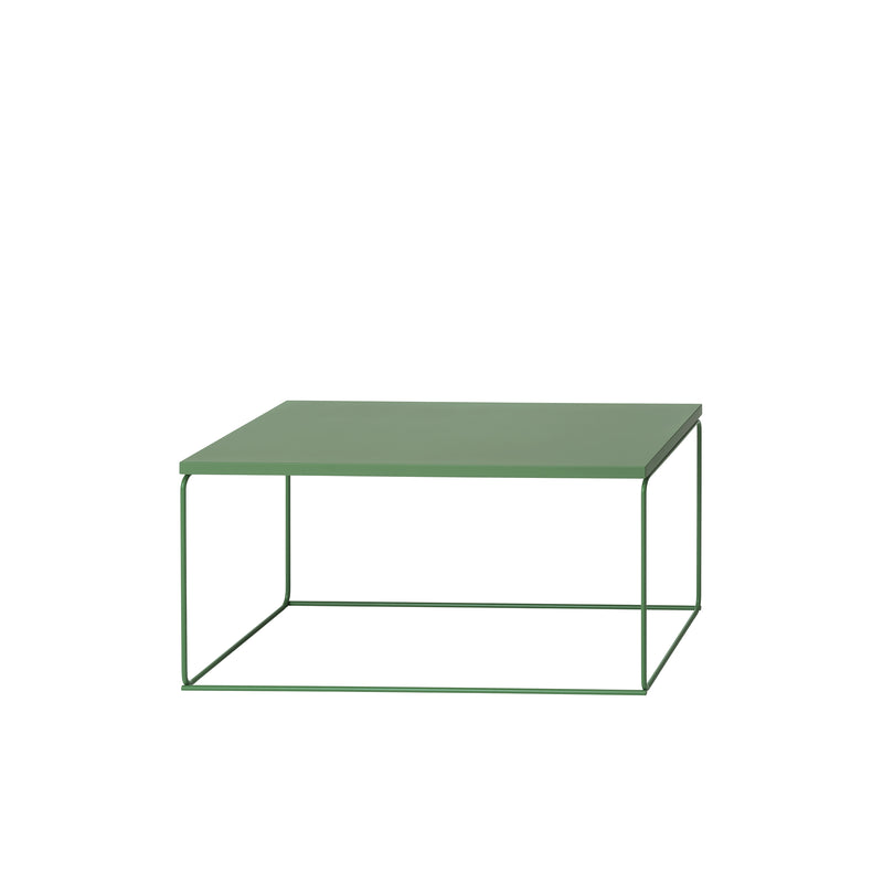 The DL1 Tangram Side Table Rectangular by Loehr features a minimalist, modern design with a green metal top and an open geometric wireframe base. This contemporary piece seamlessly complements architectural landscapes against a white background.