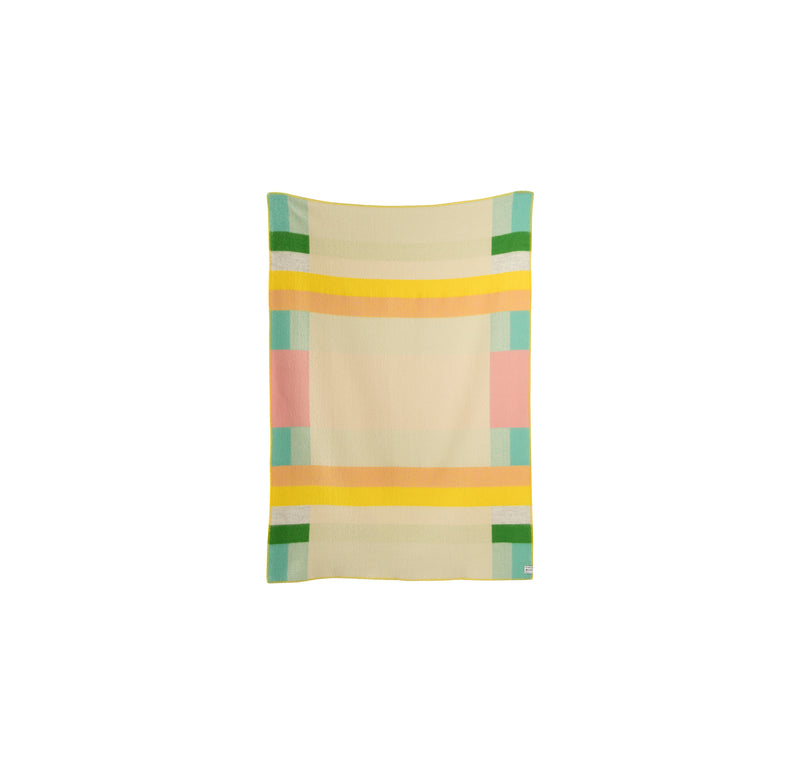 The Mikkel Large Throw by Roros boasts a Bauhaus-inspired design with geometric patterns and horizontal and vertical stripes in pastel yellow, pink, green, and blue on a light beige background.