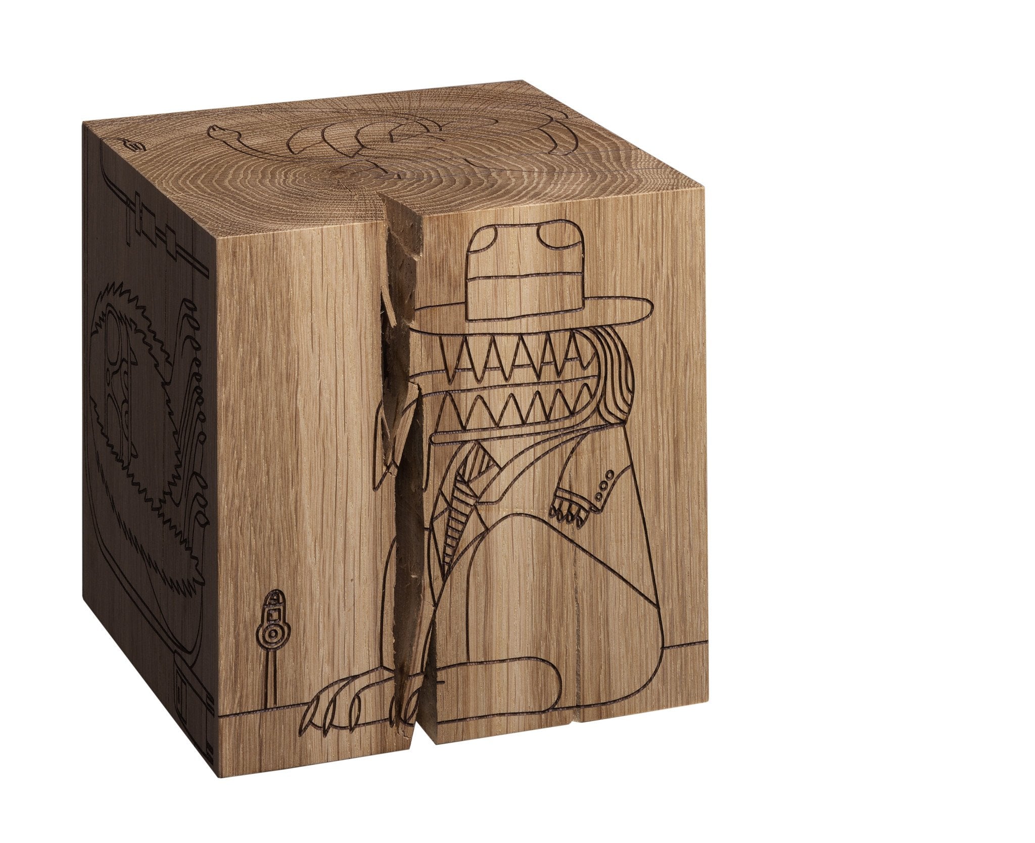 The MONSTER DICE by E15 is a wooden cube made from European oak heartwood, featuring an engraved cartoon crocodile in a suit and a laser-etched dragon. A large diagonal crack showcases its natural grain and light brown hue.