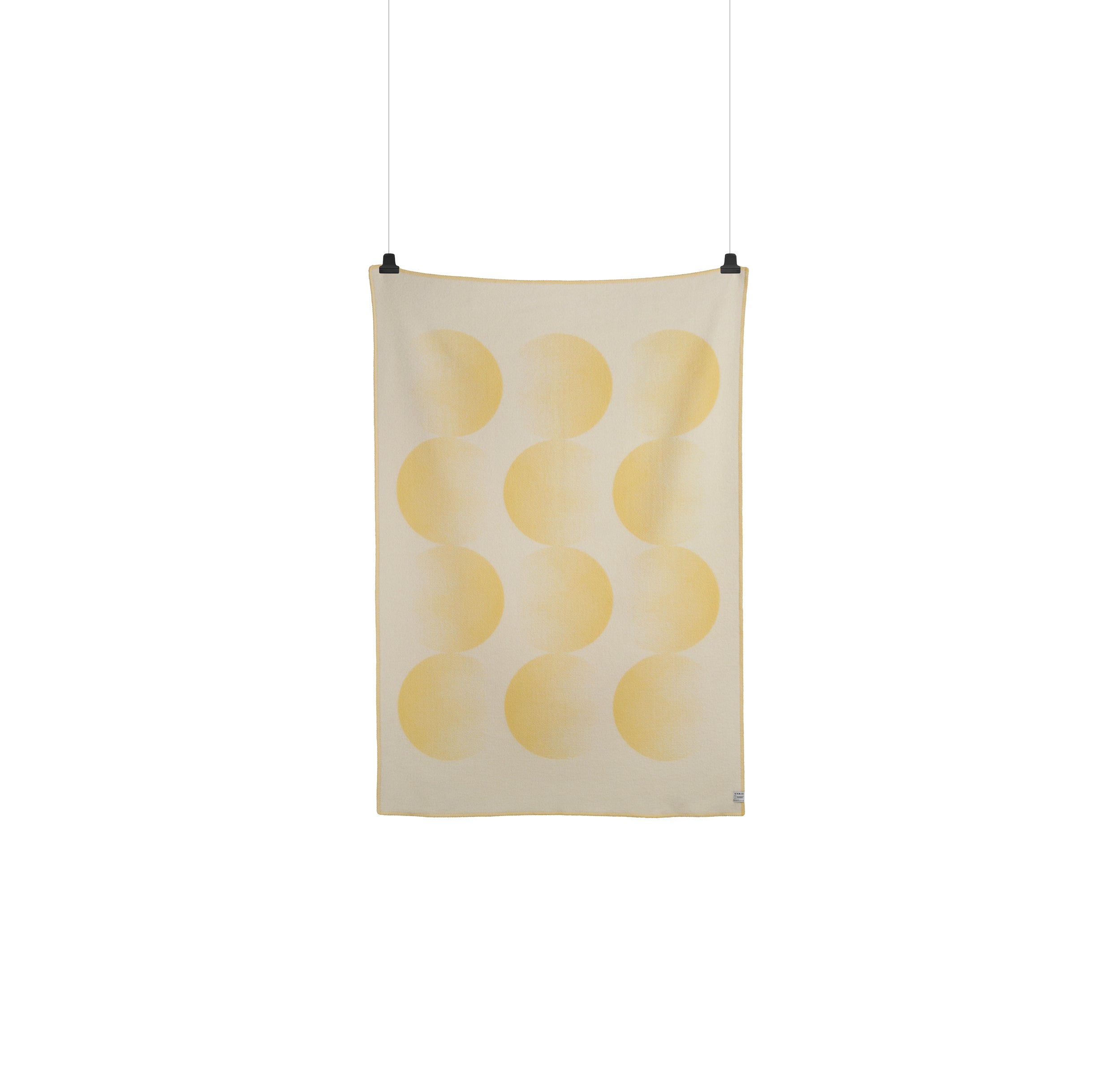 A Moon Large Throw by Roros, featuring yellow wavy vertical lines on white, hangs against a plain white background. Featuring black clips reminiscent of a Clara von Zweigbergk design.