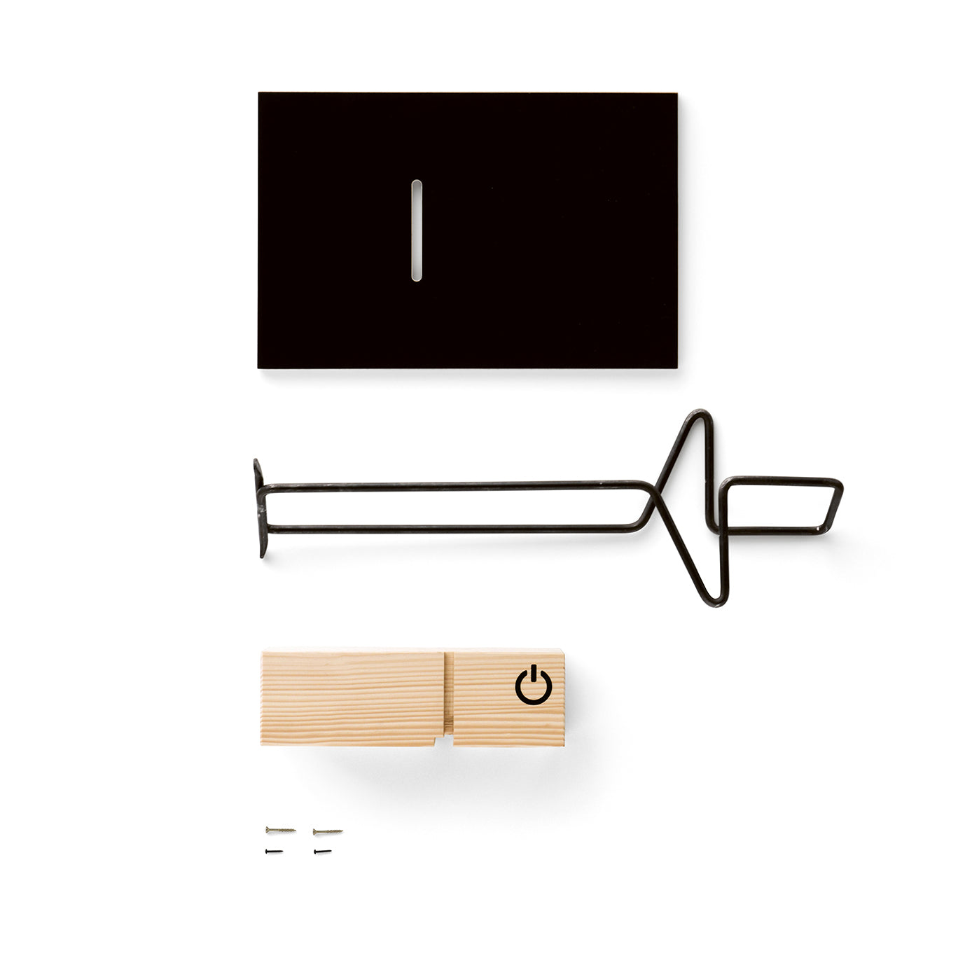 The Moormann Abgemahnt set combines a black rectangular piece with a slot, a zigzag metal rod, and a small wooden block featuring a power symbol. It includes two small metal pieces that create a dynamic contrast against the white background.