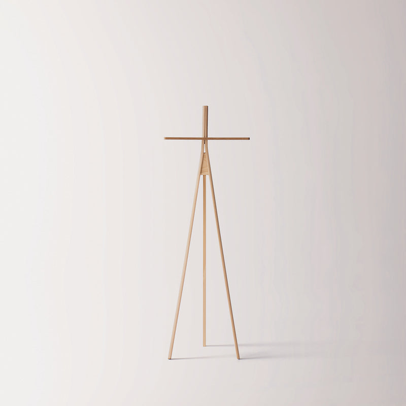 Moormanns Der Kleine Lehner is a minimalist wooden coat rack featuring a tripod base and horizontal bar, providing space-saving elegance against a plain light background.