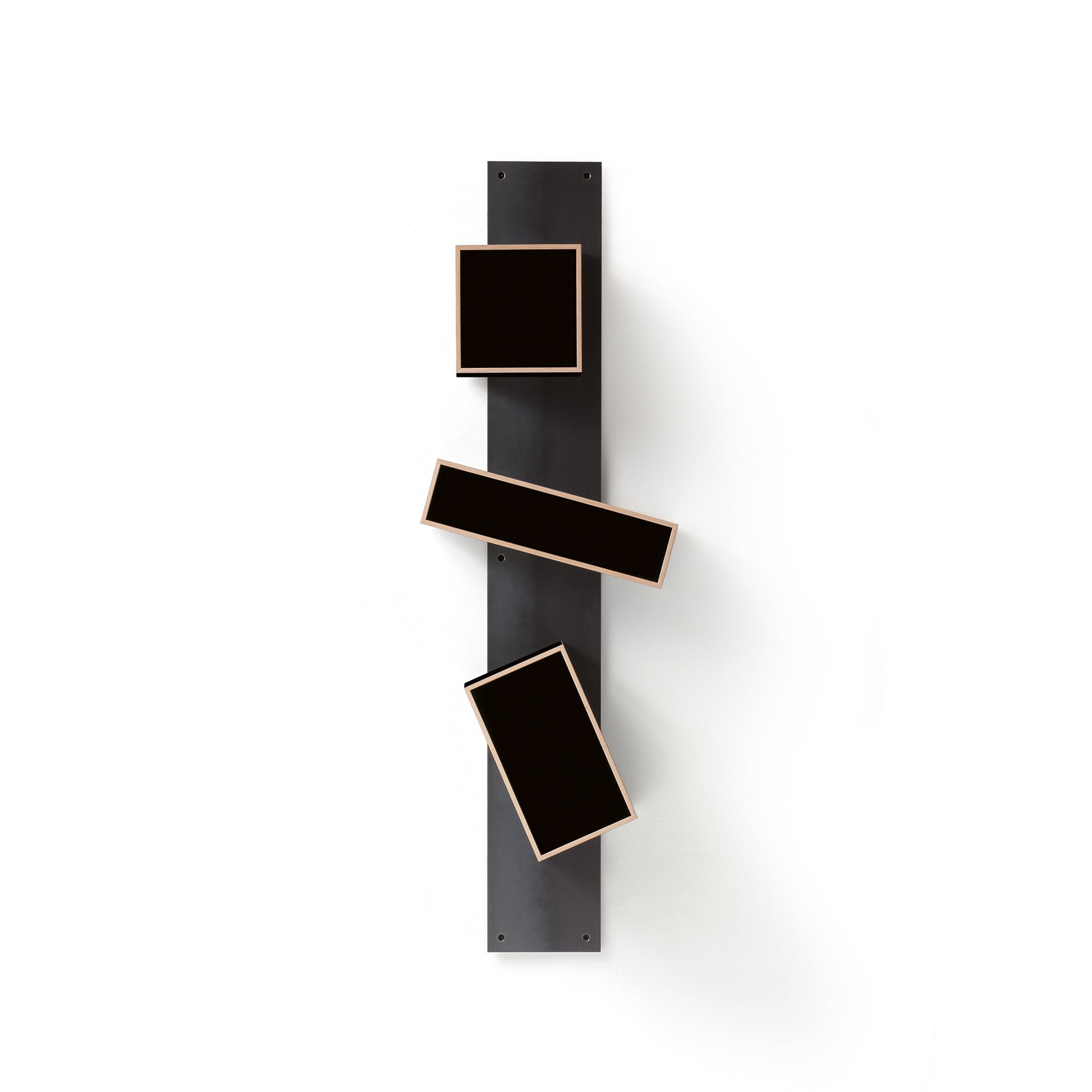 The Moormann Magnetique, a minimalist wall sculpture, includes three rectangular black panels on a vertical strip. Integrated magnets allow secure positioning at various angles, creating an abstract composition against a white background.