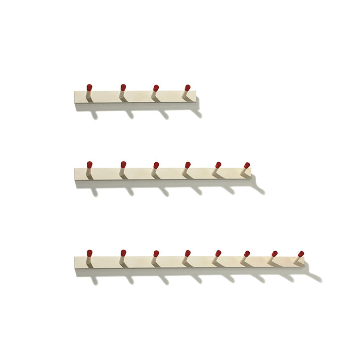 The Moormann Rechenbeispiel offers a flexible storage solution with three beige wall-mounted racks featuring vibrant red knobs and varying hook capacities (five, six, seven). Perfectly aligned against a white background, they form a sleek modular system for any space.