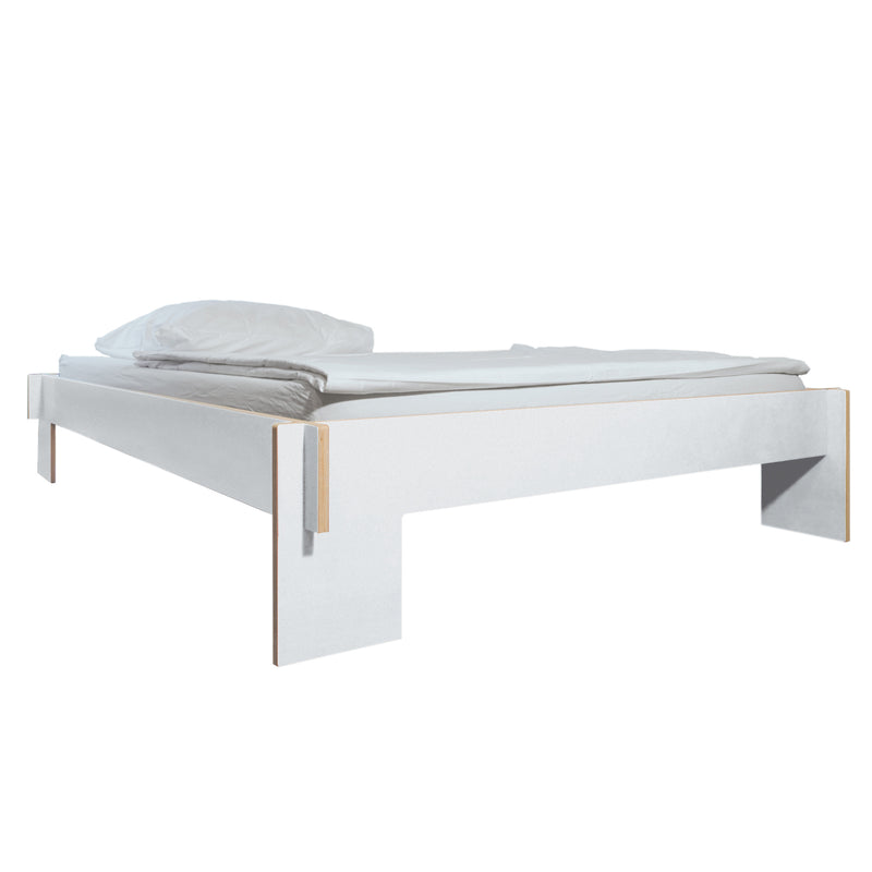 The Moormann Siebenschläfer is a minimalist birch plywood bed with clean lines and an elevated frame, featuring a pillow and folded blanket. Its modern design comes flat-packed, requiring no tools for assembly.