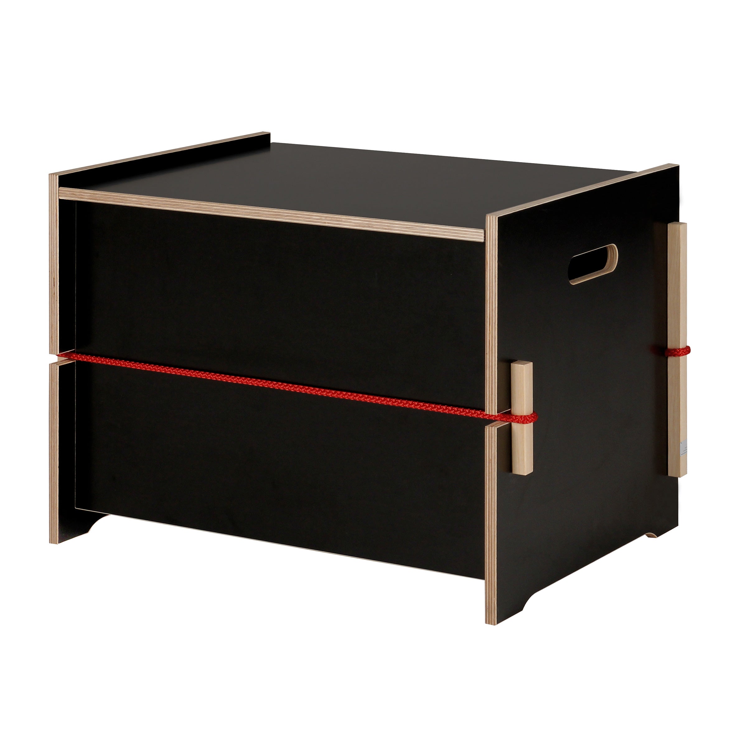 The Trude by Moormann is a modern black wooden storage box featuring cut-out handles and a red rope detail around the middle. This minimalist piece provides an elegant solution for storing bed linens, set against a plain white background.