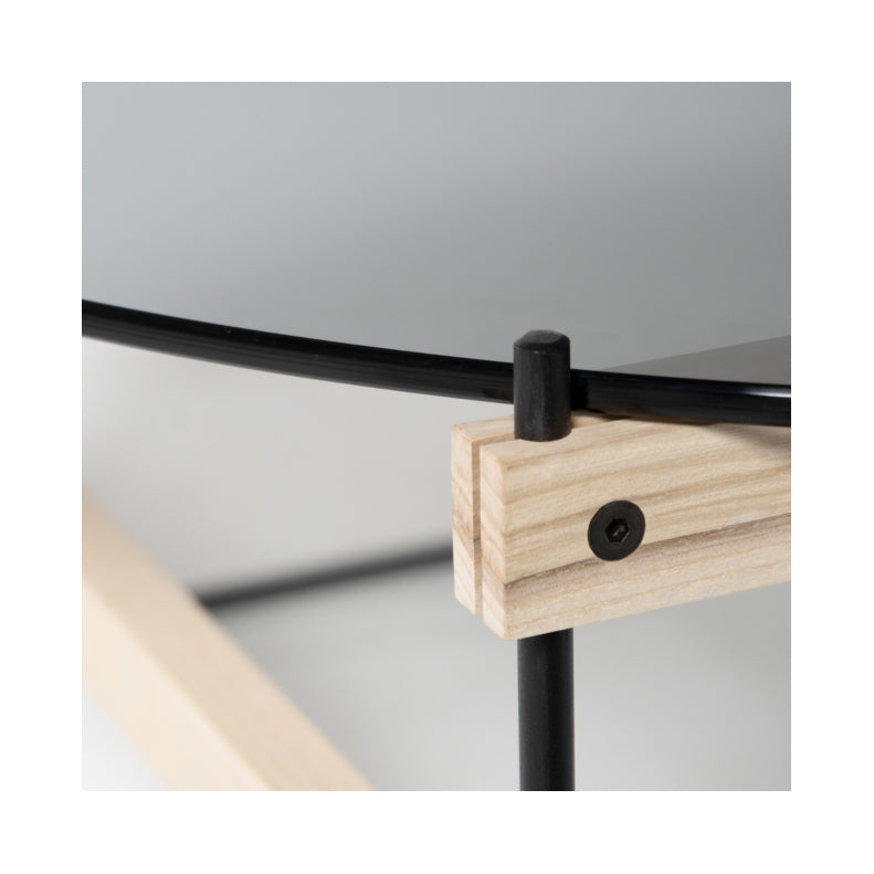 The Moormann Netto Coffee Table showcases grey ESG glass surfaces atop light wood and black metal rods, featuring a minimalist design with visible screws securing the components.