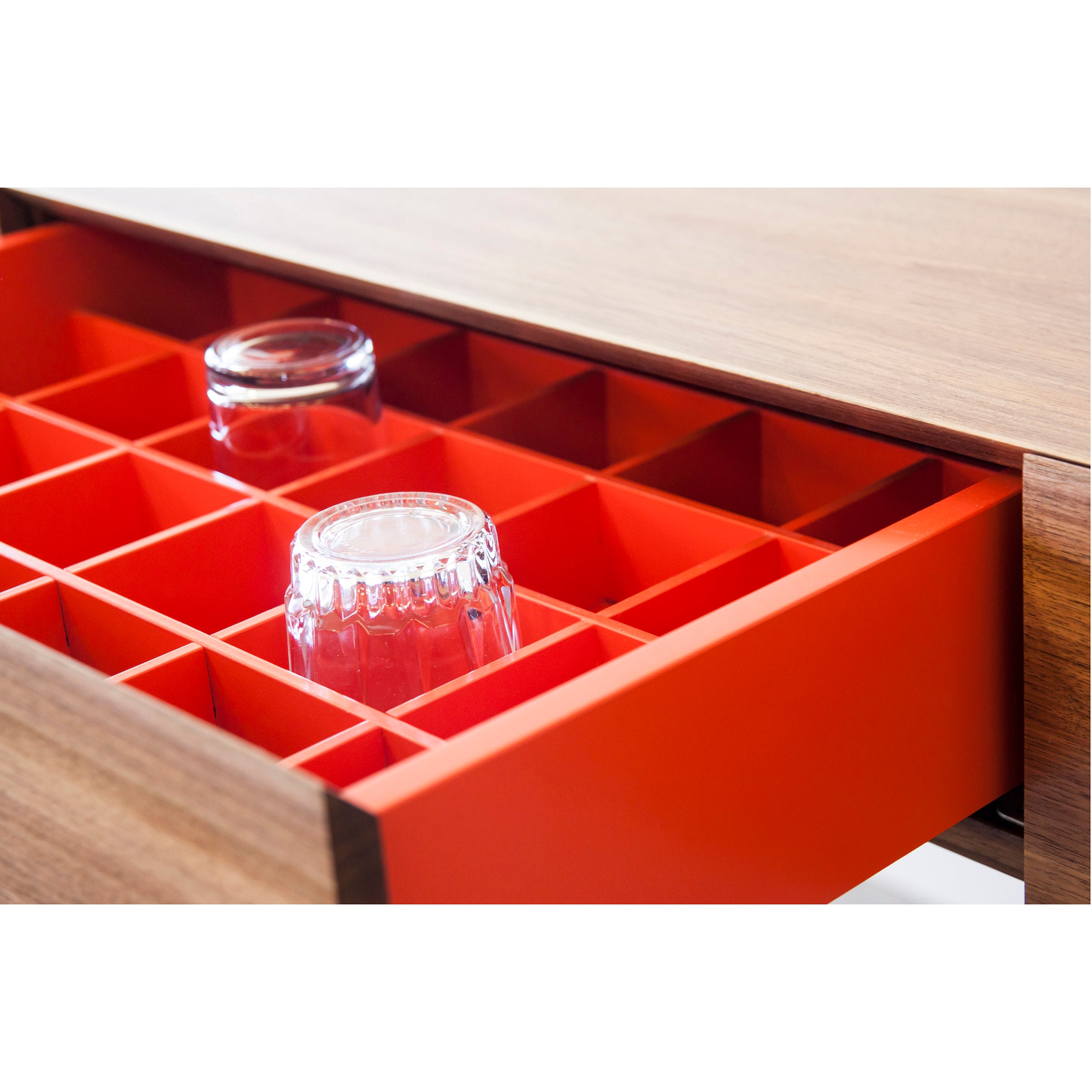 The Bar X Console by One For Hundred boasts a solid wood exterior with a vibrant orange grid insert, ideal for holding upside-down glass cups. The removable insert enhances versatility, and the bold grid pattern and contrasting colors offer an eye-catching display.