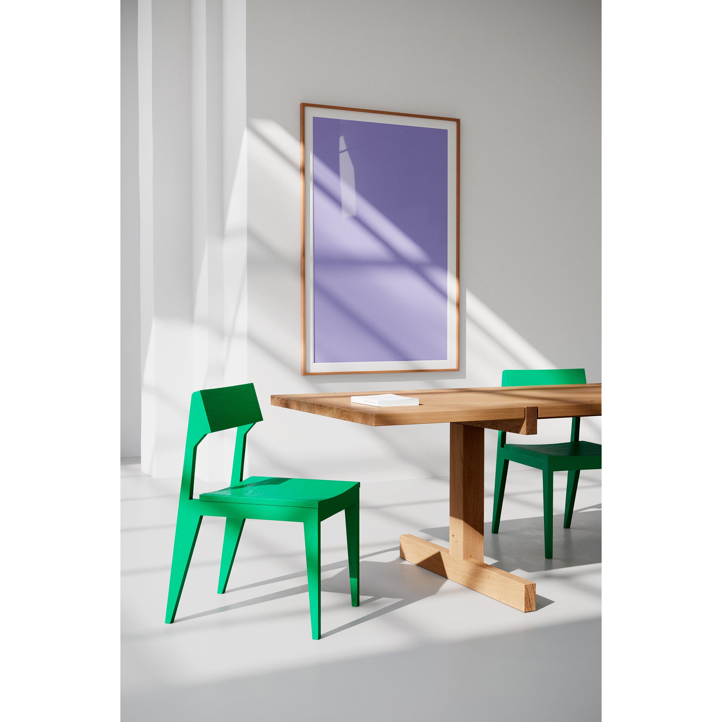 A modern interior includes two durable green Schulz Chairs by Objekte unserer Tage and a solid ash wood table. A purple and white abstract painting by SCHULZ enhances the wall, as sunlight creates serene shadows on the minimalist white floor and walls.