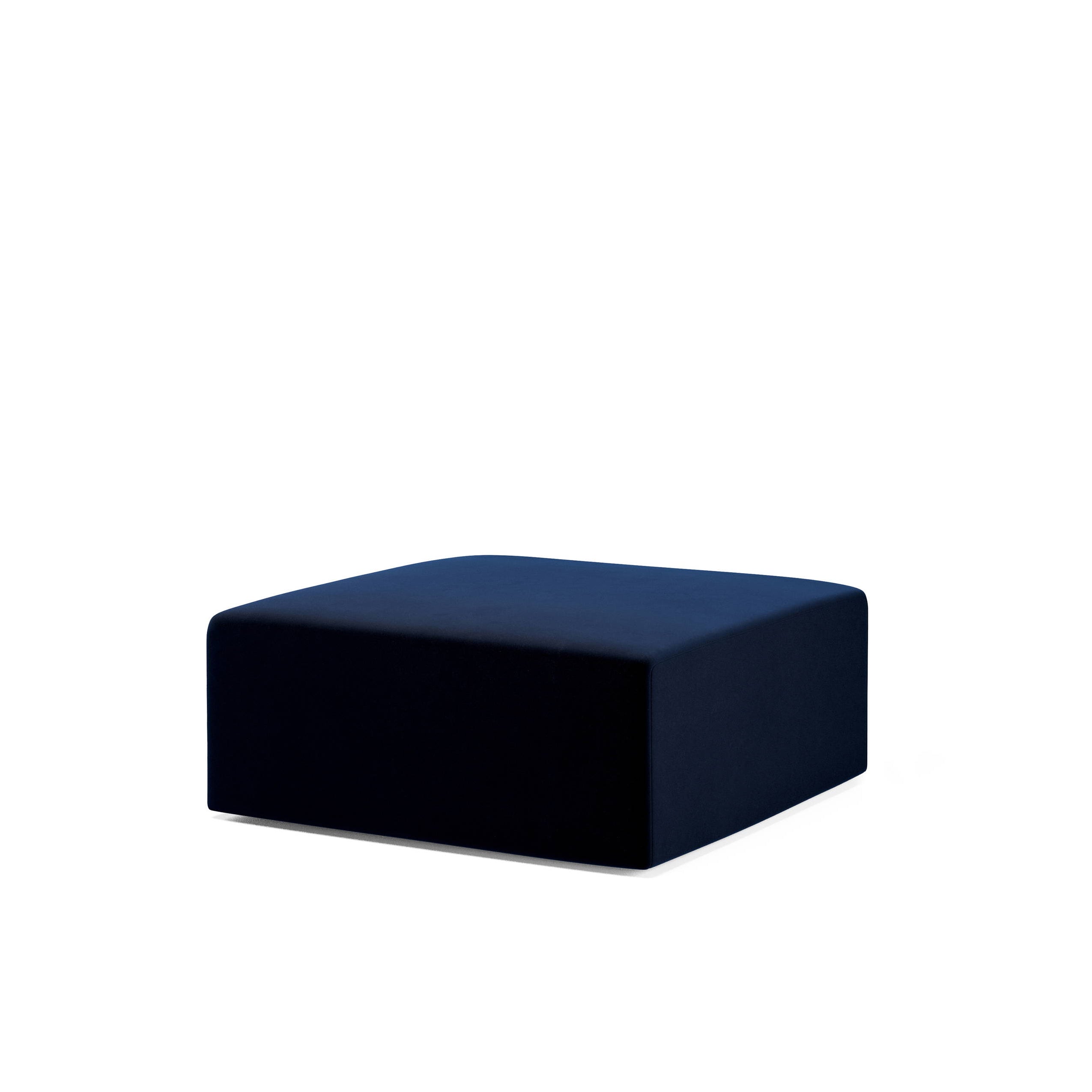The Weber Pouf, by Objekte unserer Tage, is a minimalist, dark blue rectangular ottoman on a white background. Inspired by basic geometric shapes, it features clean lines without visible seams for a modern look.