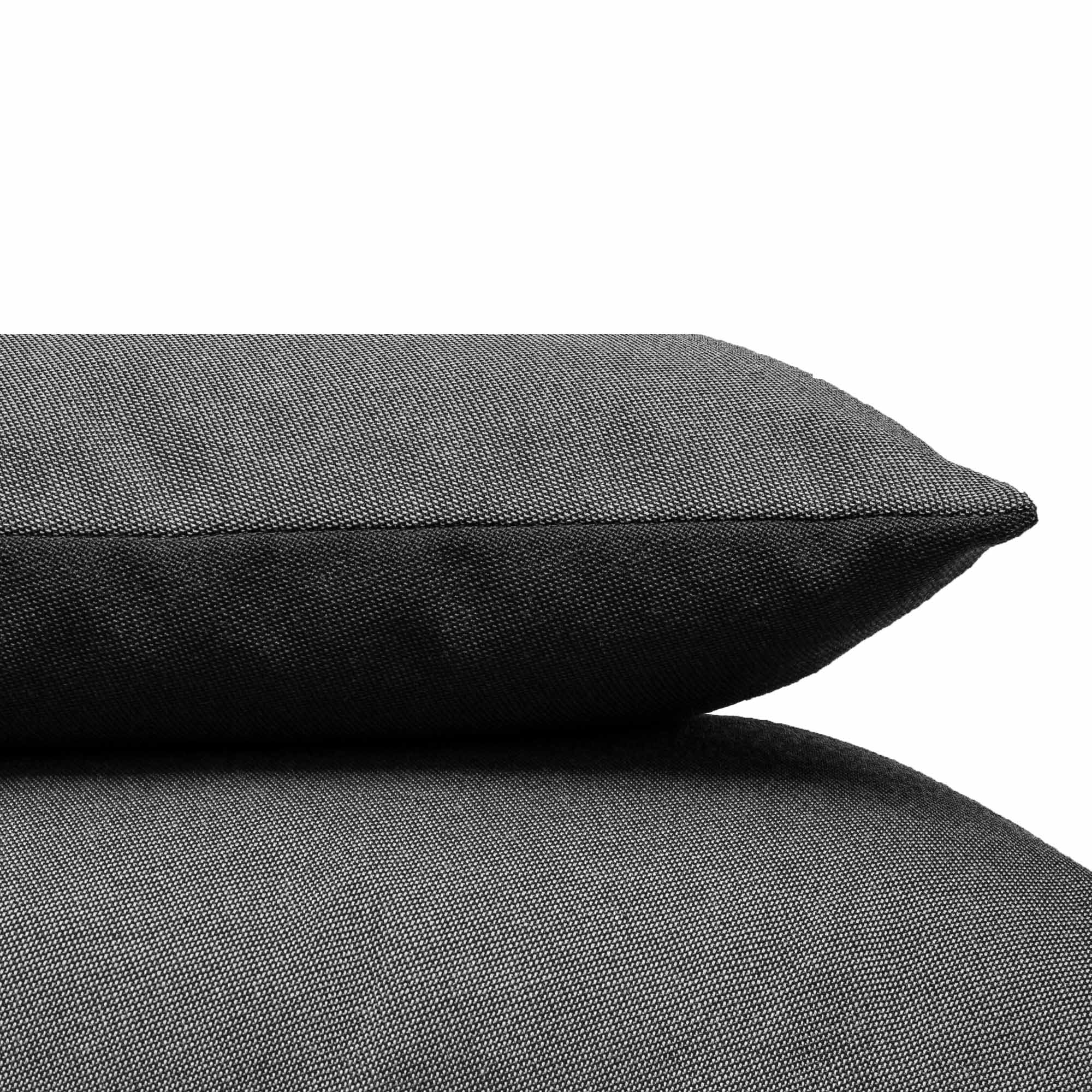 A close-up of two gray Weber Cushion pieces from Objekte unserer Tage, stacked against a plain white backdrop. The textured Weber upholstery fabric enhances their cozy and soft appearance.