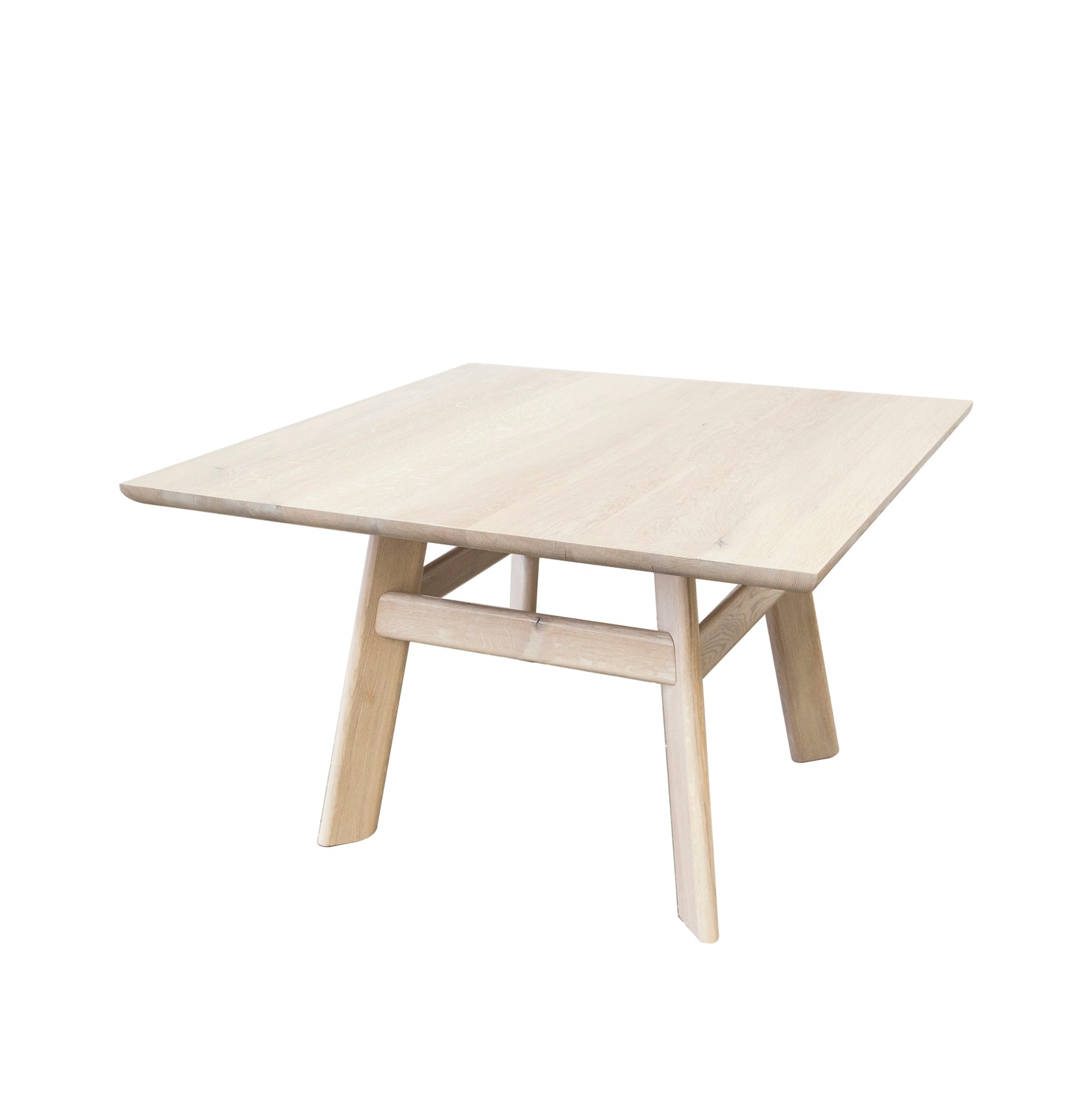 The YOGI Table by One For Hundred is a square wooden piece with a light finish, four sturdy angled legs, and a minimalist design. Its solid wood construction exudes timeless elegance.