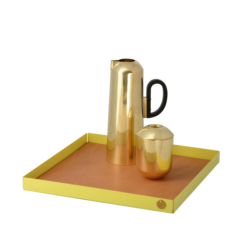 The Victor Foxtrot POI Tray XL is adorned with a sleek gold carafe and black-handled container, all elegantly placed on a square golden tray with raised edges. Crafted from powder-coated steel, this modern set suits design enthusiasts who value the elegance of POI trays.