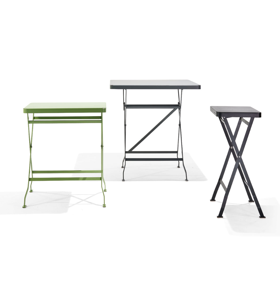 Three Richard Lampert Flip Side Tables are neatly arranged: the left has a green top, the middle is larger with a gray surface, and the right is smallest with a dark top. All feature sleek metal frames.