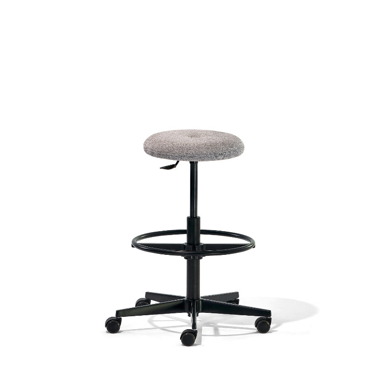 The Mr. Round High Chair by Richard Lampert is a gray cushioned swivel stool with a round seat and black metal base. It features an adjustable footrest ring, five caster wheels for mobility, and a gas spring system for height adjustment, all set against a white background.