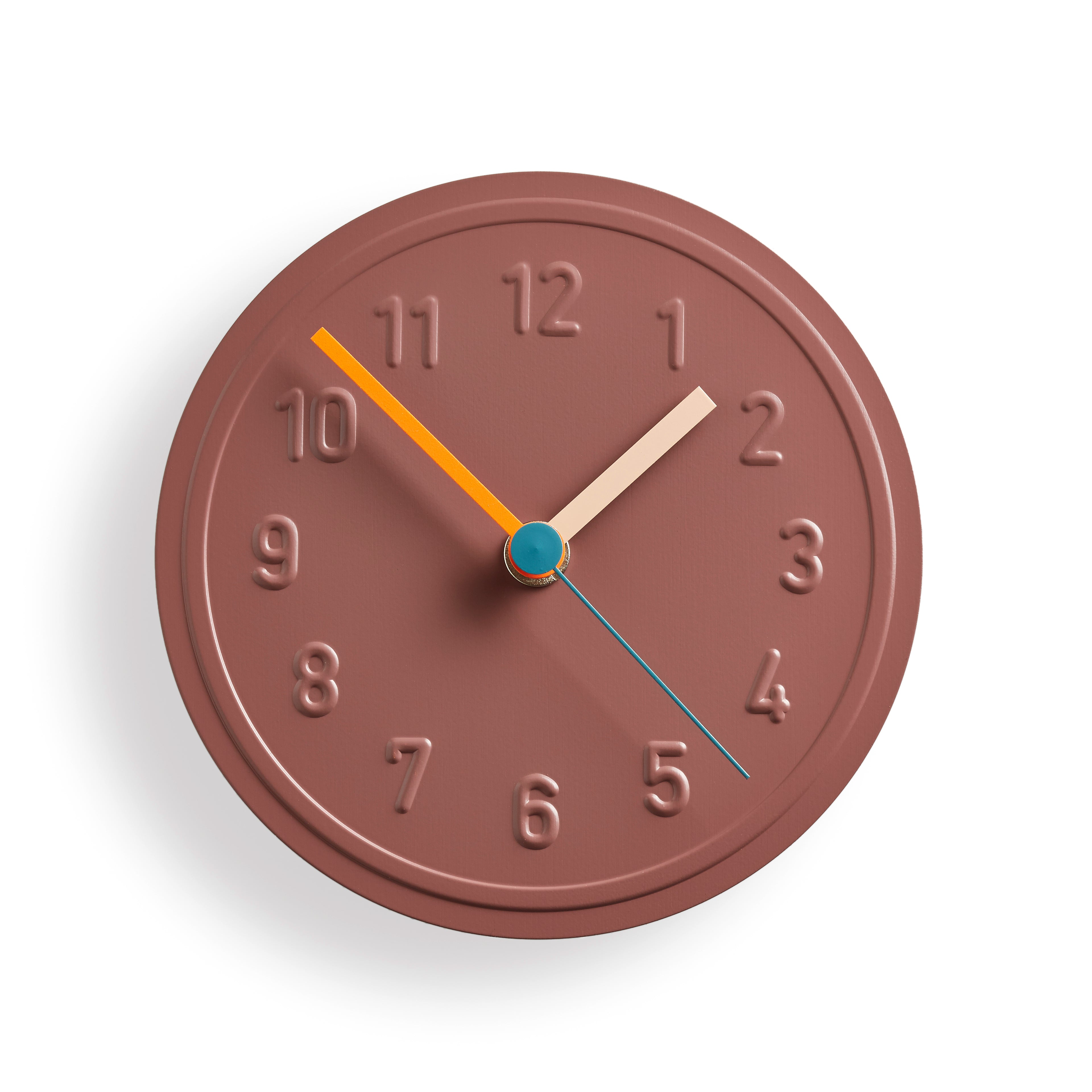 The Alu Alu Wallclock by Richard Lampert, designed by Jochen Gros, is a round, brown quartz clock featuring evenly spaced embossed aluminum numbers and colorful hands: an orange hour hand, a cream minute hand, and a blue second hand.