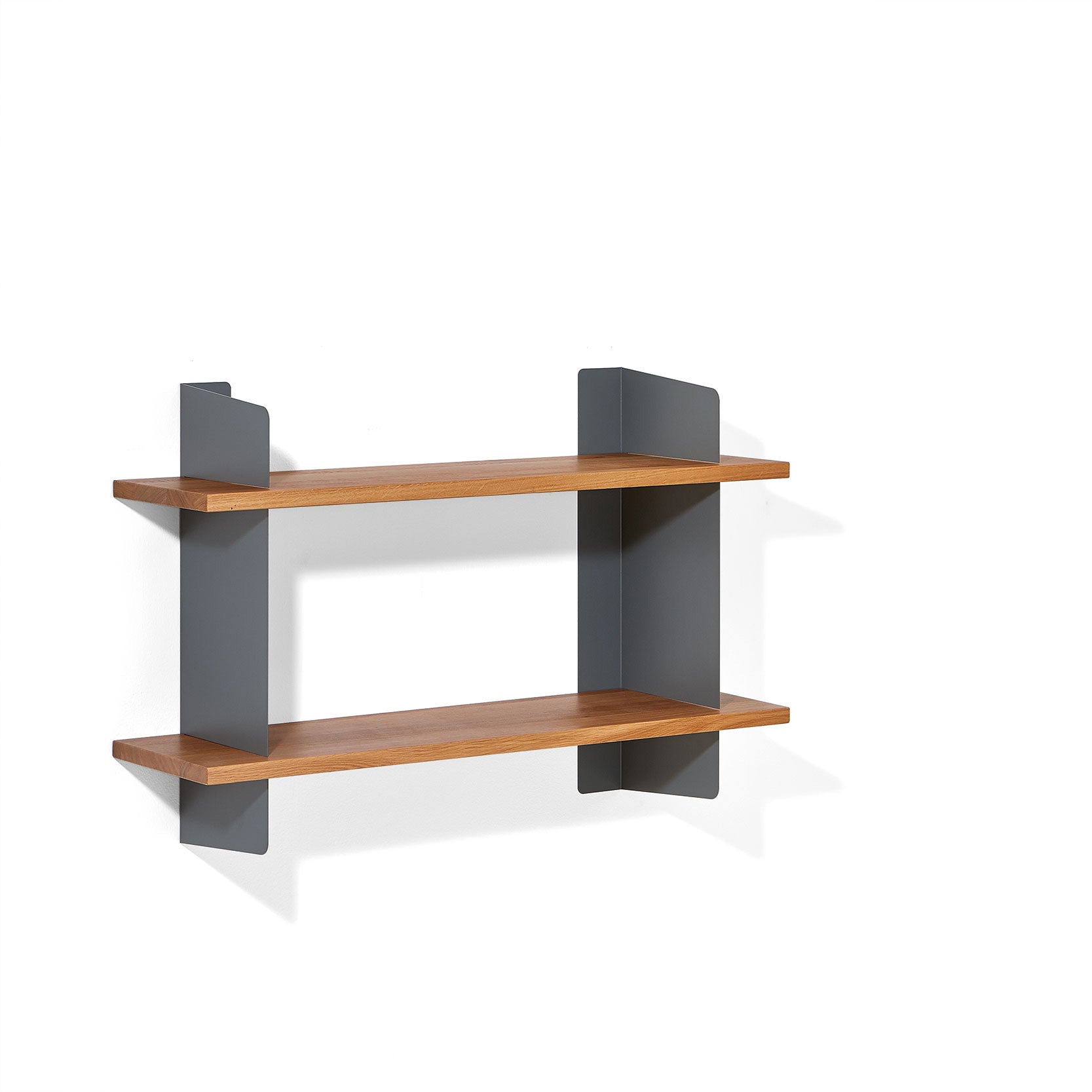 The Atelier by Richard Lampert is a minimalist floating wall shelf with two wooden shelves and sleek gray steel brackets, set against a white background.