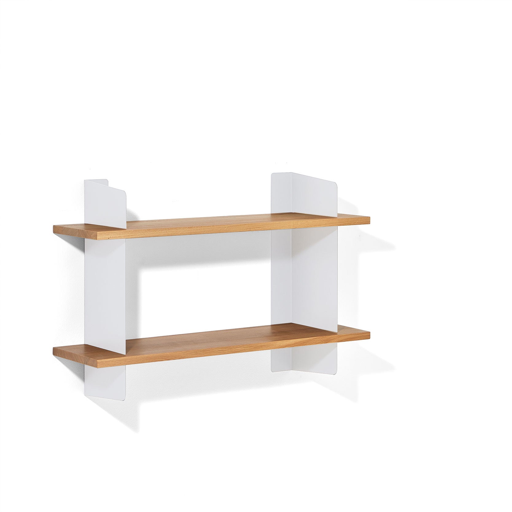 The Richard Lampert Atelier shelf combines sophistication and functionality with its minimalist design, featuring two wooden shelves and sleek white steel brackets for a modern, clean look against a white backdrop.