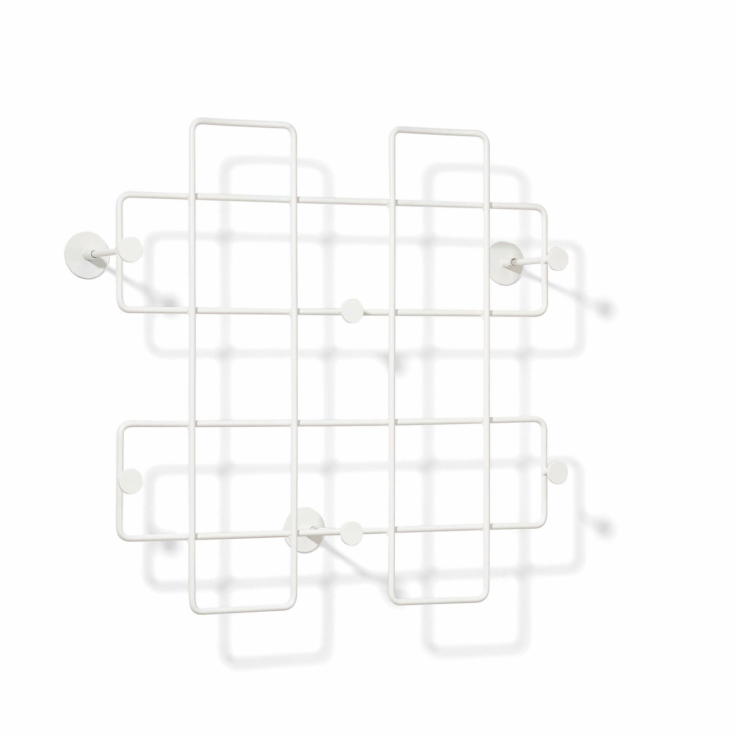 The Bazar Coat Rack by Richard Lampert has a sleek, white geometric design with a grid pattern and several rounded hooks, perfect for enhancing home organization. Its powder-coated steel ensures durability and mounts on a white wall, casting soft shadows.