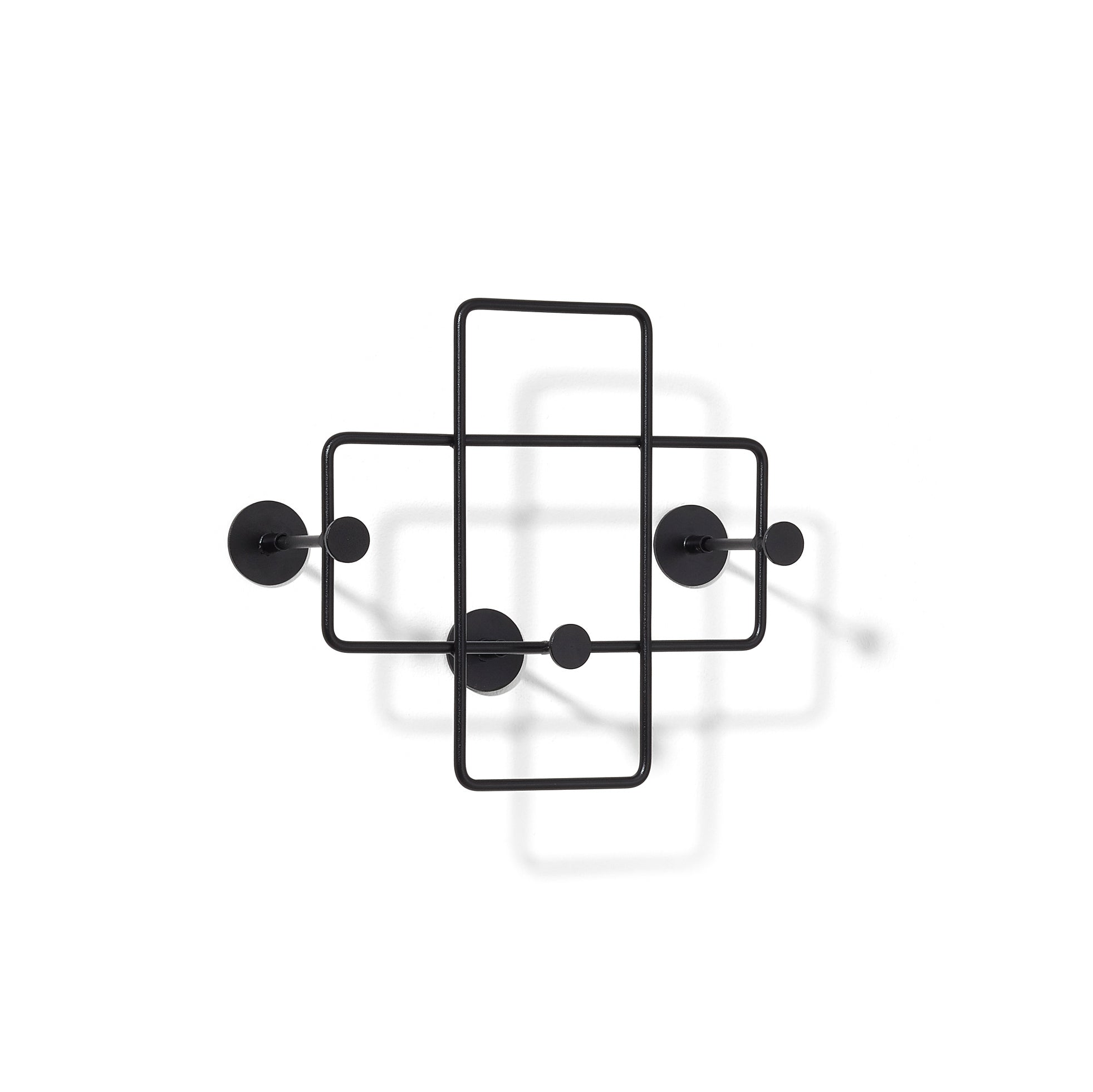 The Bazar Coat Rack by Richard Lampert, crafted from sleek black metal, features intersecting geometric shapes and circles with a steel powder coating, creating intriguing shadows on a white backdrop.