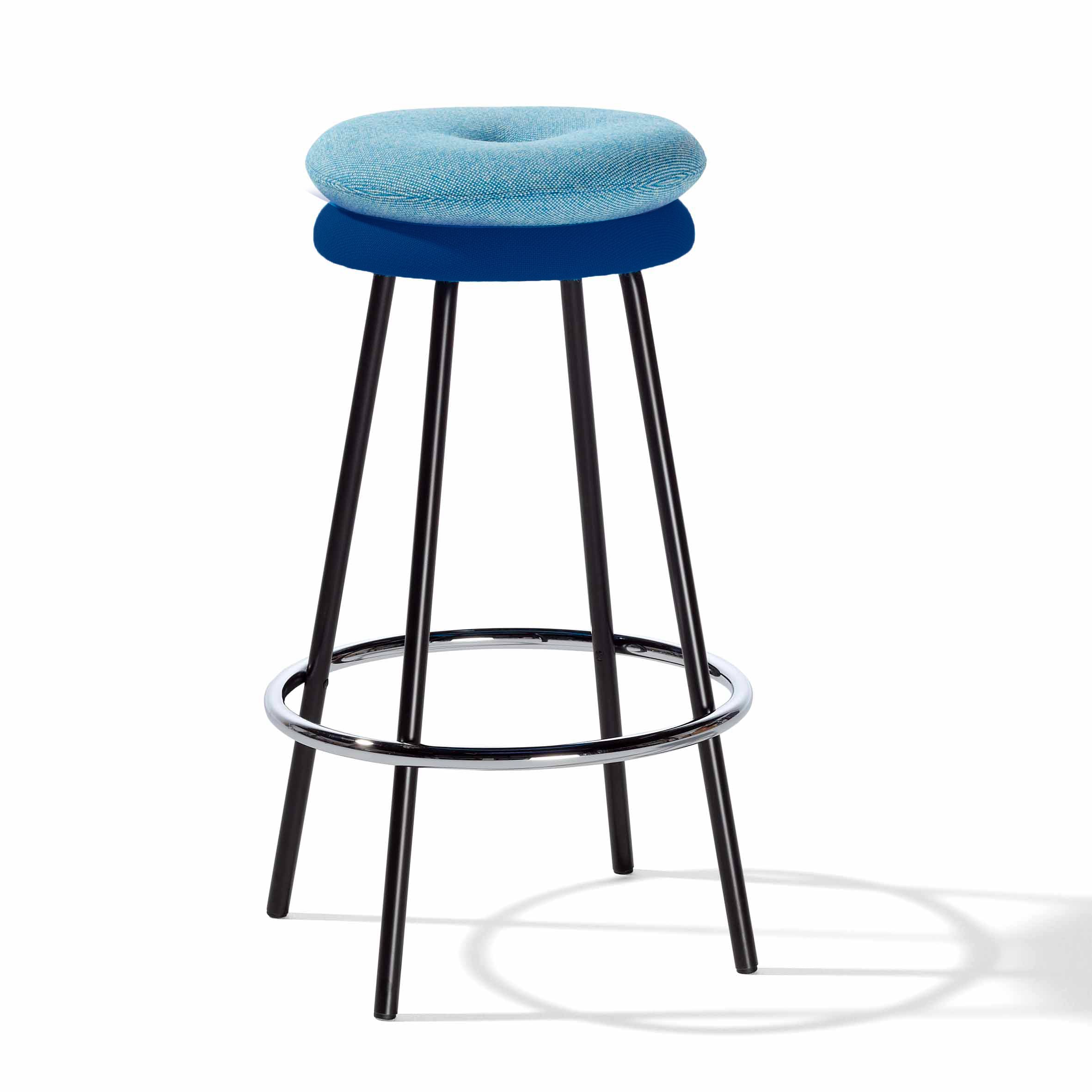 The Richard Lampert Big Tom Barstool features a circular blue cushioned seat with leather and textile covers, supported by four black metal legs, a chrome footrest, and a sturdy tubular steel frame that elegantly shadows the ground.