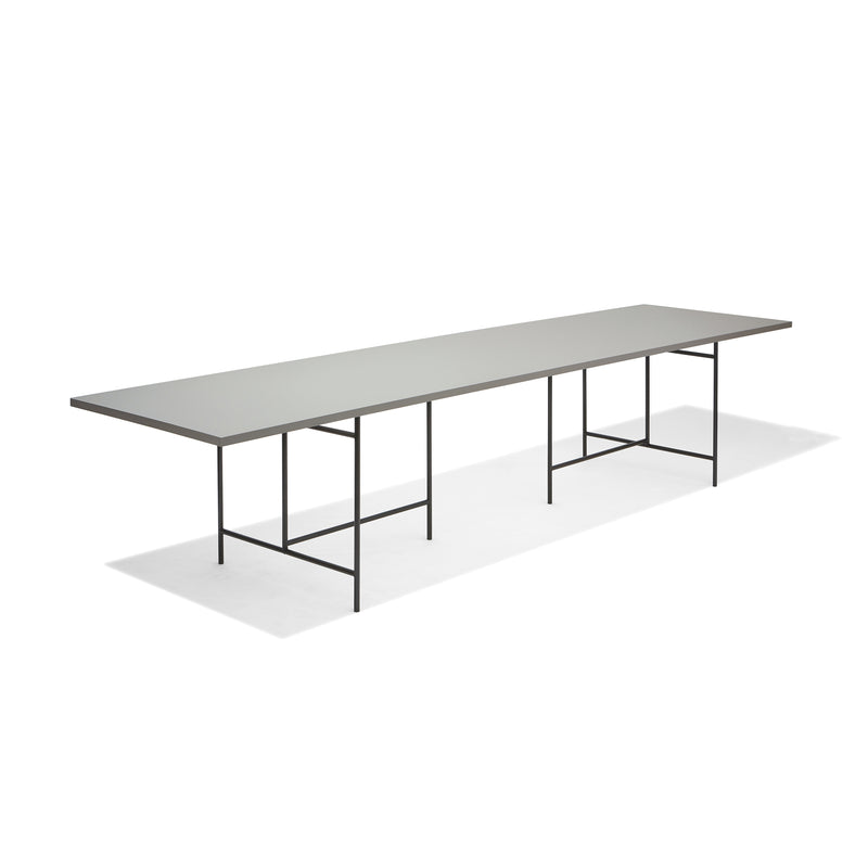 The Eiermann 3 Table by Richard Lampert features a modern, minimalist style with a thin, light gray surface and slender black metal legs, ideal for worktops or conference tables.