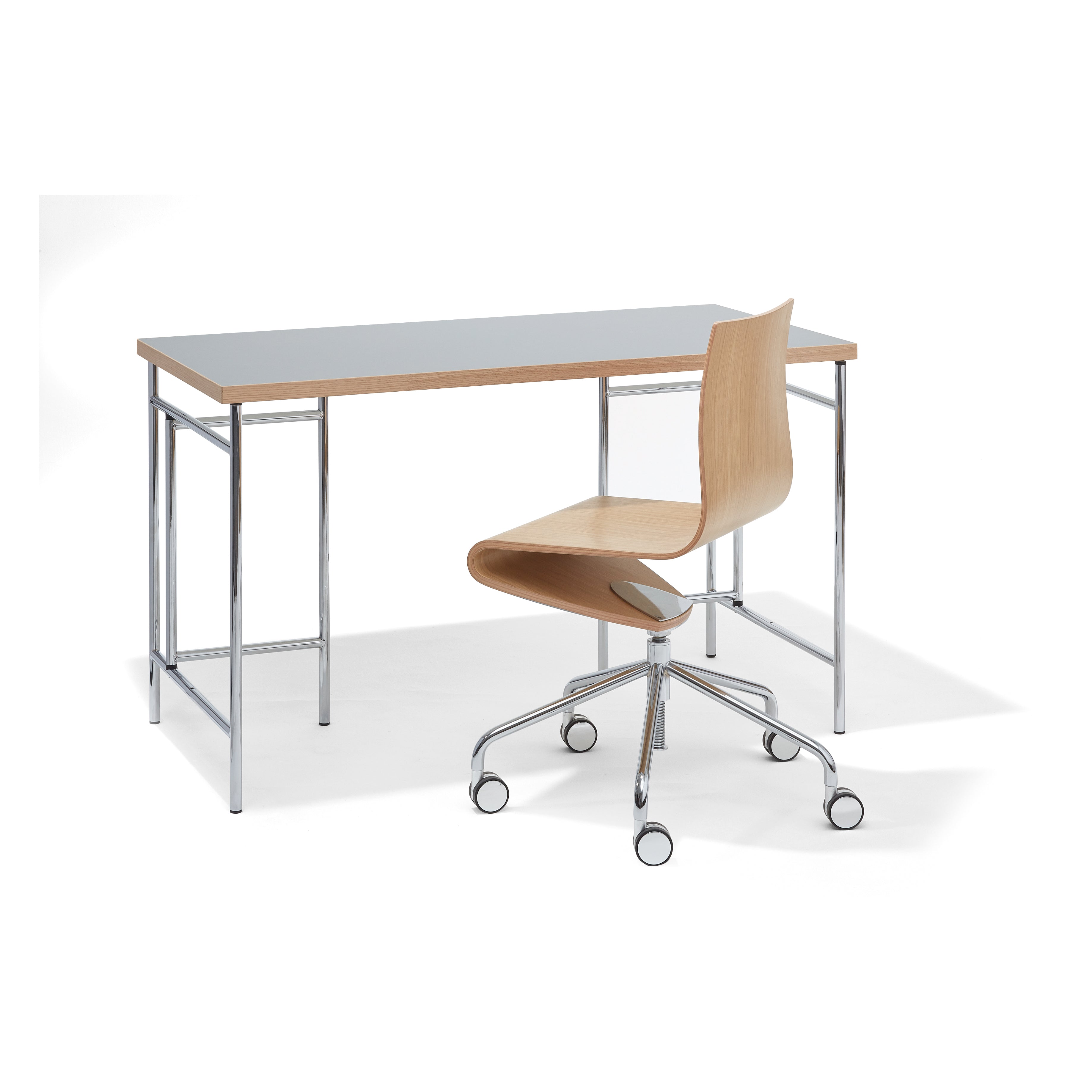 A minimalist office setup includes the Eiermann 3 Table by Richard Lampert, featuring a wooden top and metal legs for a sleek, modern design. Complementing it is a wooden office chair with a curved backrest and five-wheel chrome base, ideal for a contemporary workspace.