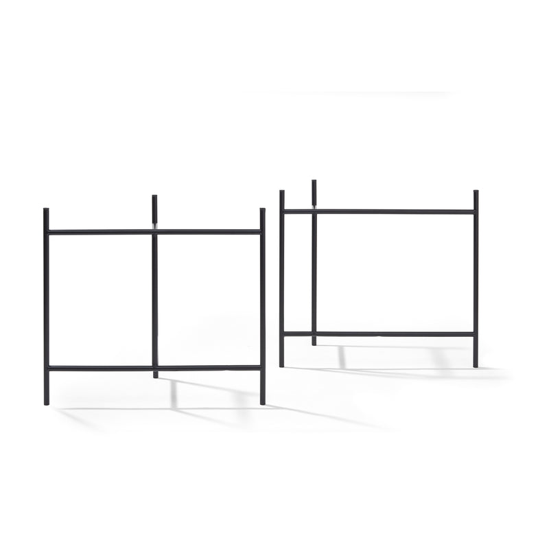 Two minimalist black metal frame structures on a white background, echoing Eiermann 3 Table by Richard Lampert, resemble simple stands. Their rectangular symmetry and cast shadows evoke the clean aesthetics of modern worktops akin to elegant Eiermann designs.