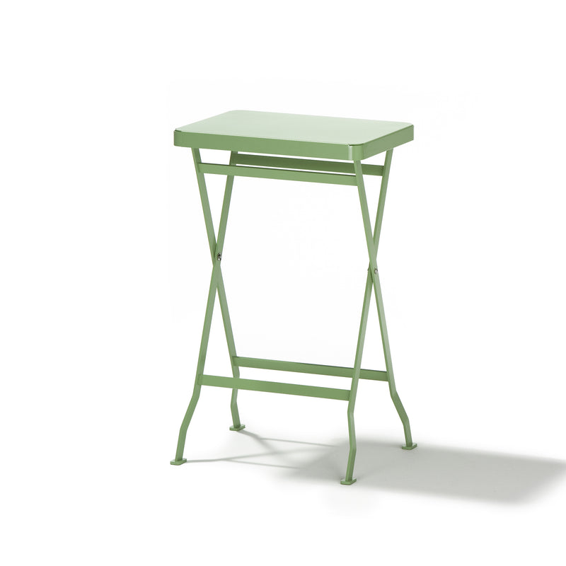 The Richard Lampert Flip Side Table is a premium quality, light green folding table with a sleek rectangular top and slim, crossed stainless steel legs set against a plain white background.