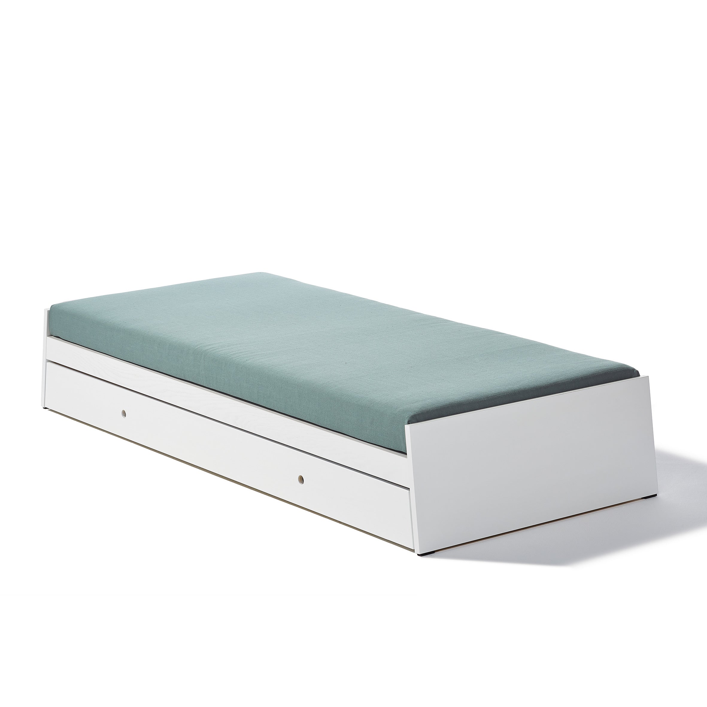 The Lönneberga Stacking Bed by Richard Lampert is a sleek, minimalist white daybed with a teal mattress. Featuring clean lines and a pull-out drawer for storage, this versatile piece is perfect for saving space in any room.
