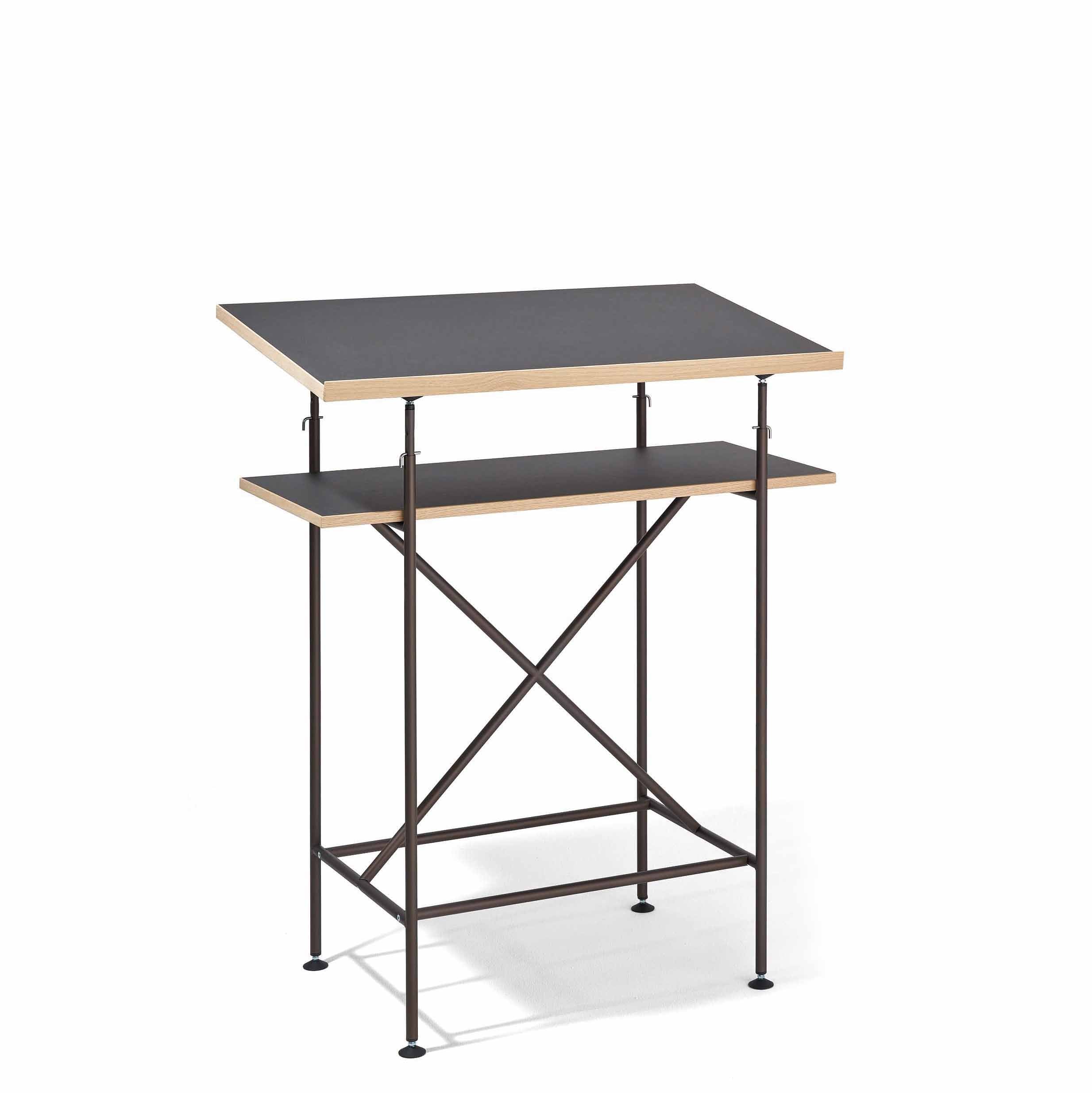 The Milla High Desk by Richard Lampert features a sleek black top and a secondary shelf, all supported by a black metal frame with X-shaped crossbars for stability. Inspired by the Eiermann table, its perfect for active sitting or standing in a minimalist style.
