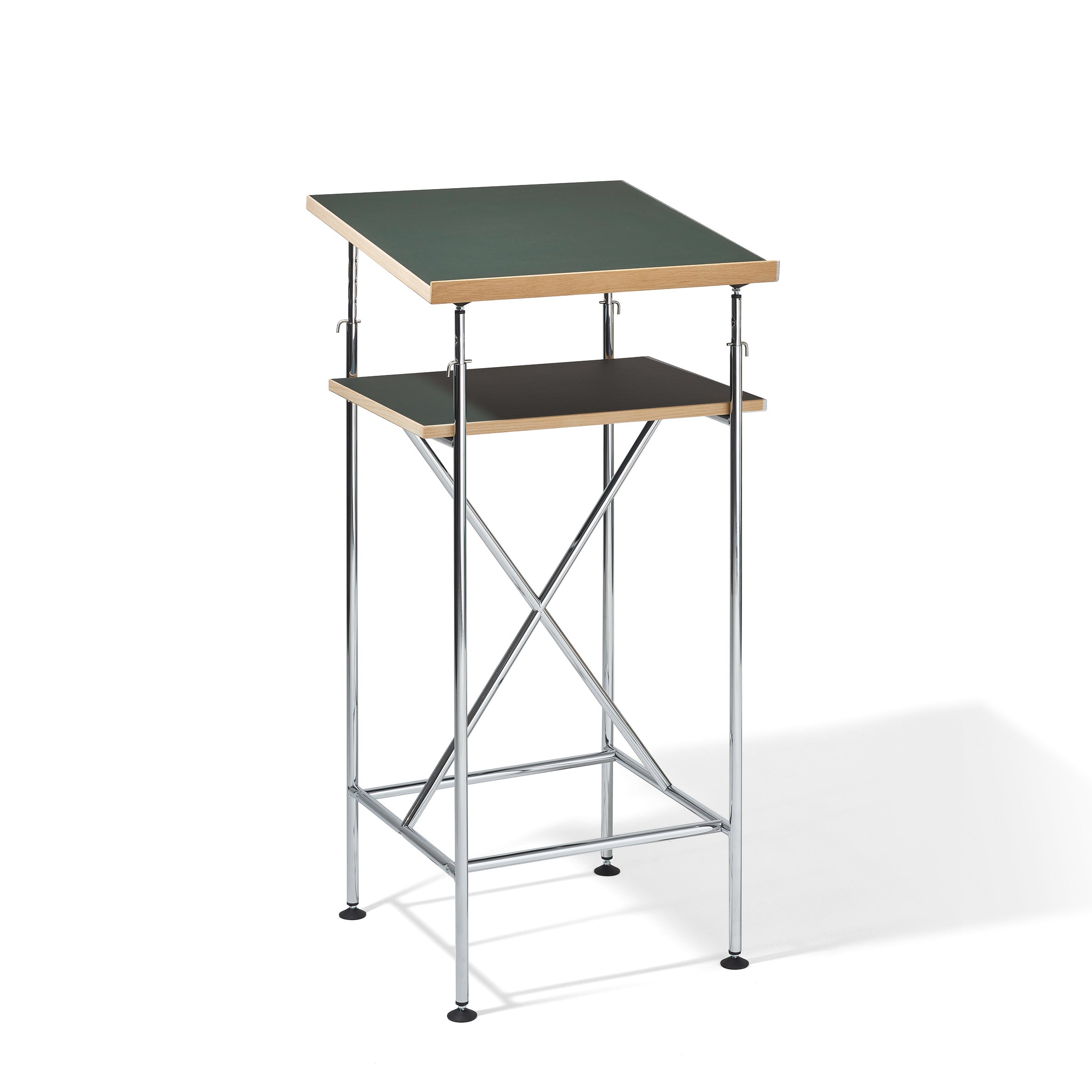 The Milla High Desk by Richard Lampert is a contemporary lectern similar to an Eiermann table, featuring a green slanted top, black flat shelf, and metal frame with X-shaped support. It includes adjustable brackets for active sitting and standing on four round feet.