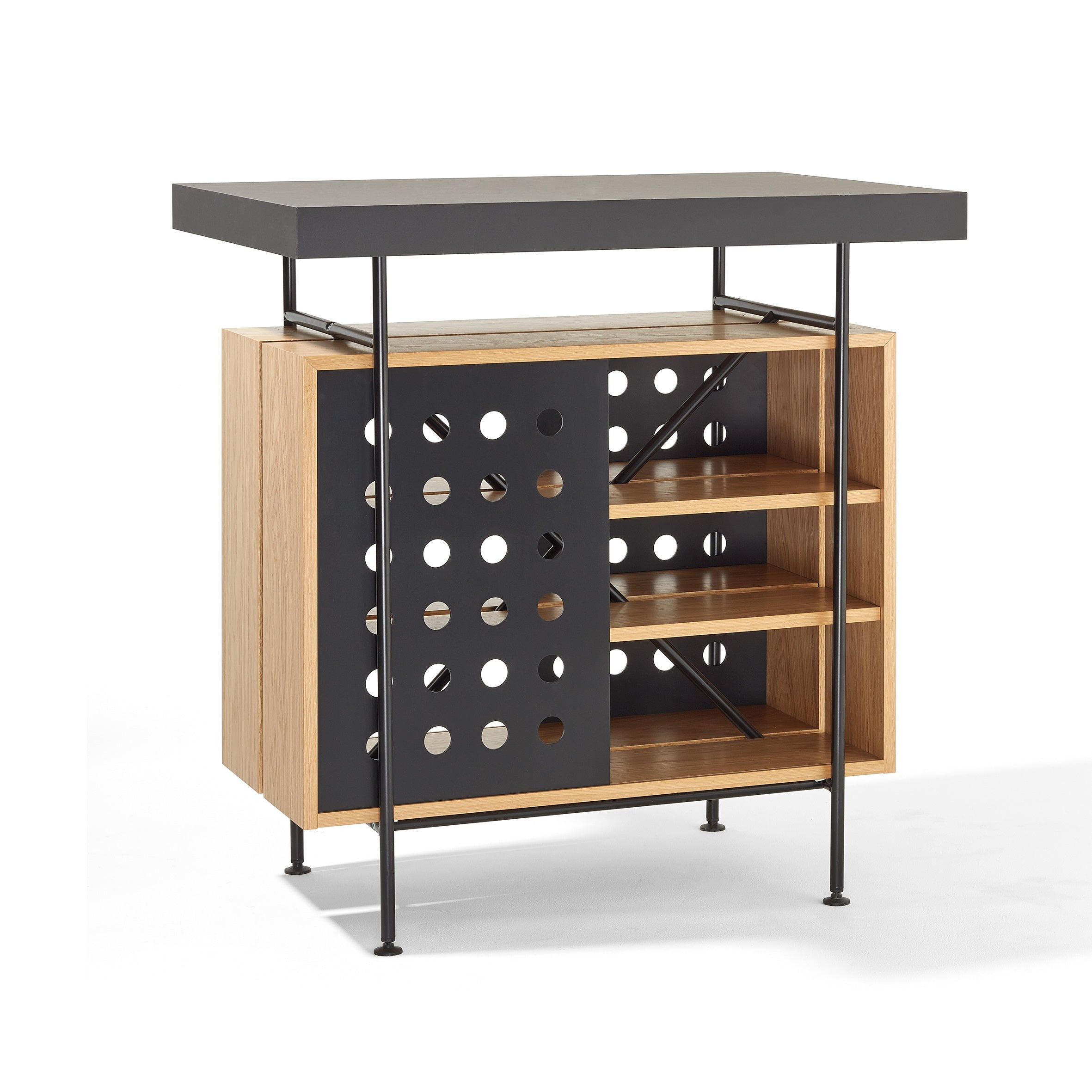 The Milla Bistro Table by Richard Lampert features a flat black top with circular cutouts, complemented by a wooden cabinet and open shelves. Its slender black metal legs provide ample storage space, making it an ideal addition to any modern bar setting.
