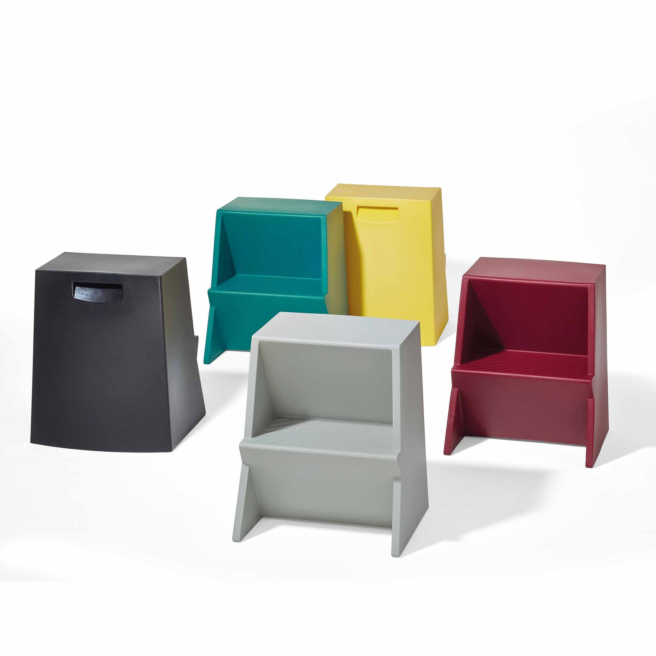 Richard Lamperts Mono Stepstool features modern, stackable wedge-shaped stools crafted from recyclable polyethylene. Available in black, teal, yellow, gray, and red, each lightweight stool includes a rectangular cut-out handle and is artfully displayed on a white background.