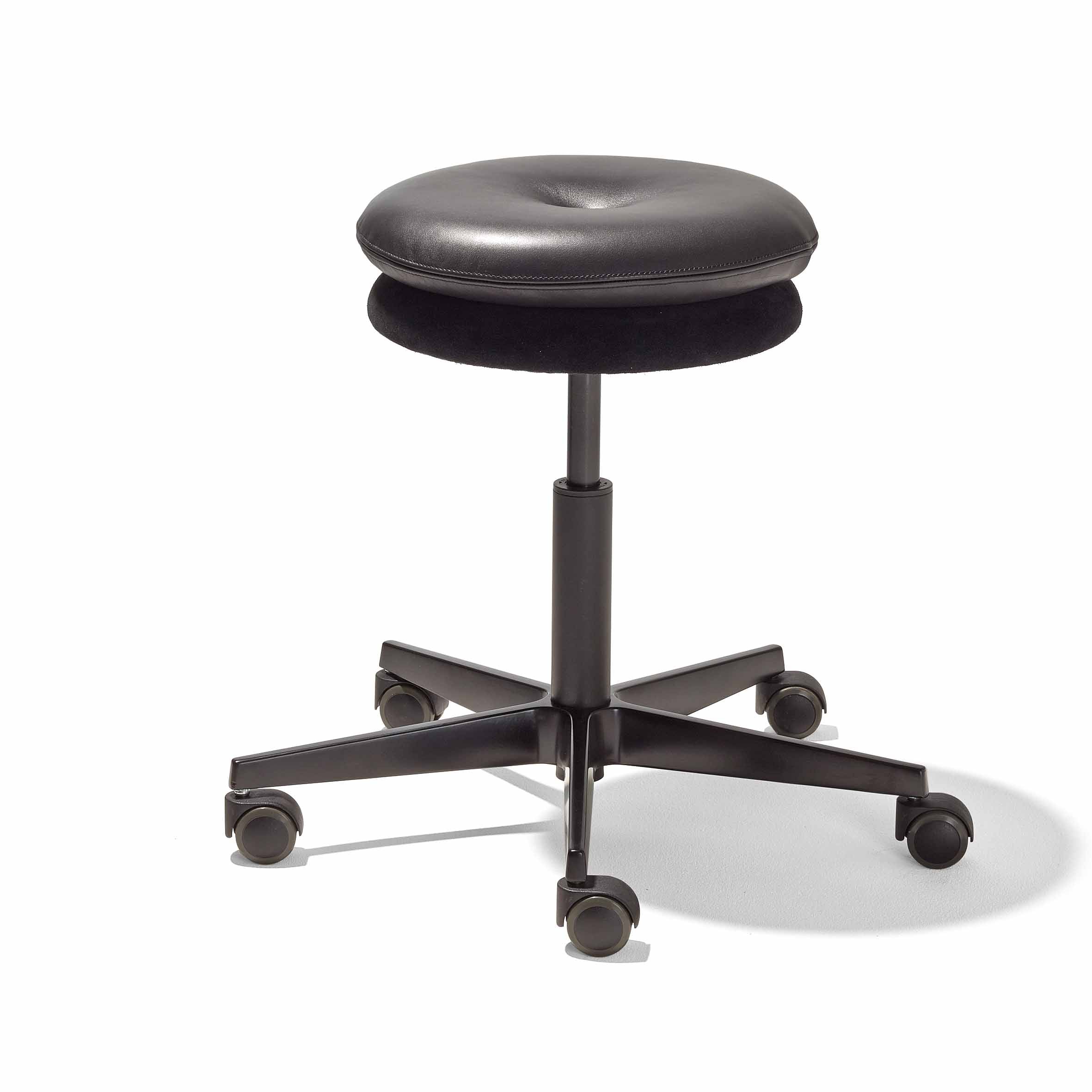 The Richard Lampert Mr. Round Swivel Stool is black with a round cushioned seat, five caster wheels on a star-shaped base, and features height adjustments via a gas spring system. It lacks armrests and a backrest for enhanced mobility and comfort in any workspace.