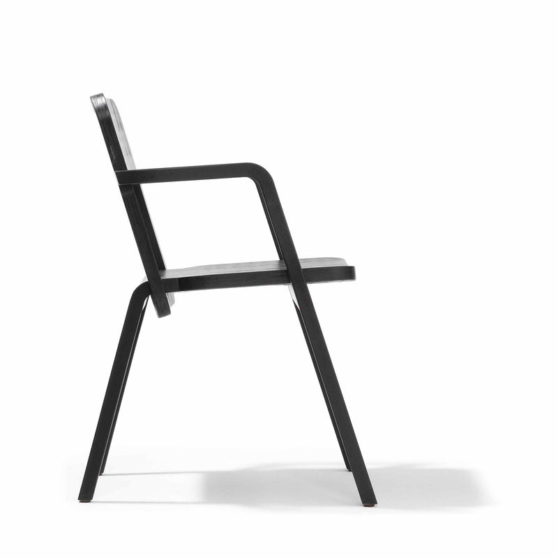 The Prater Chair by Richard Lampert offers a side view of its sleek, modern design, crafted from birch plywood. The chairs minimalist aesthetics are highlighted by its angular form and smooth finish achieved through precision CNC milling.