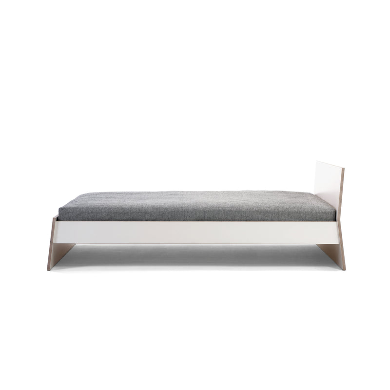 The Stockholm Bed by Richard Lampert features a sleek modern design with a minimalist white frame, light gray mattress, and an angled birch plywood headboard, all crafted by Alexander Seifried. It boasts low-profile, sturdy construction and is photographed against a plain white background.