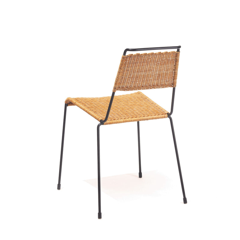 The TT54 Rattan by Richard Lampert features an ergonomic design with a woven wicker seat and backrest, supported by a minimalistic steel rod frame. Its simple and elegant style makes it ideal for indoor settings.