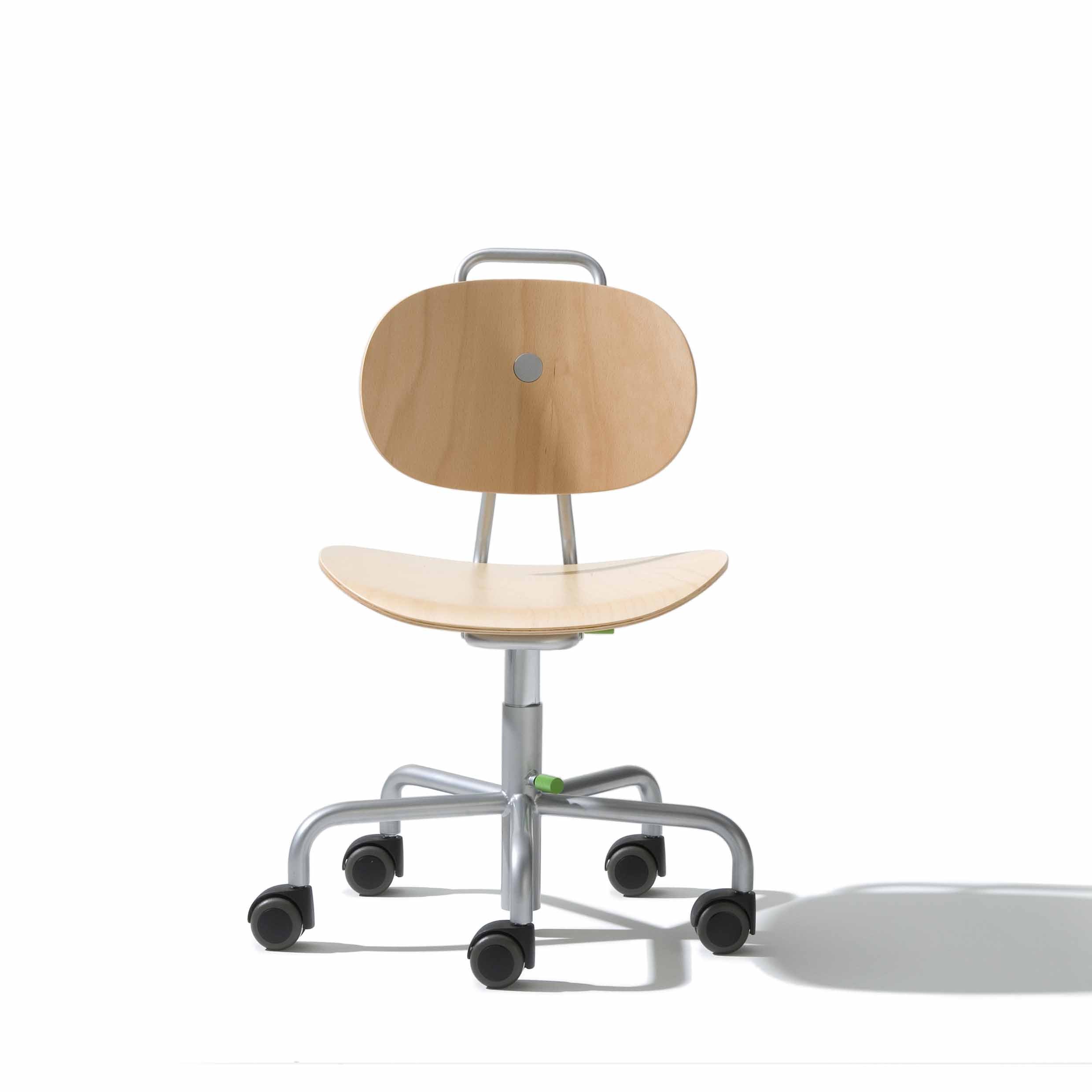 The Turtle Kids Chair by Richard Lampert is a wooden office chair featuring a curved backrest and seat on a height-adjustable metal base with five wheels for mobility. It includes a metal handle at the top of the backrest and colorful fabric covers, all against a white background.