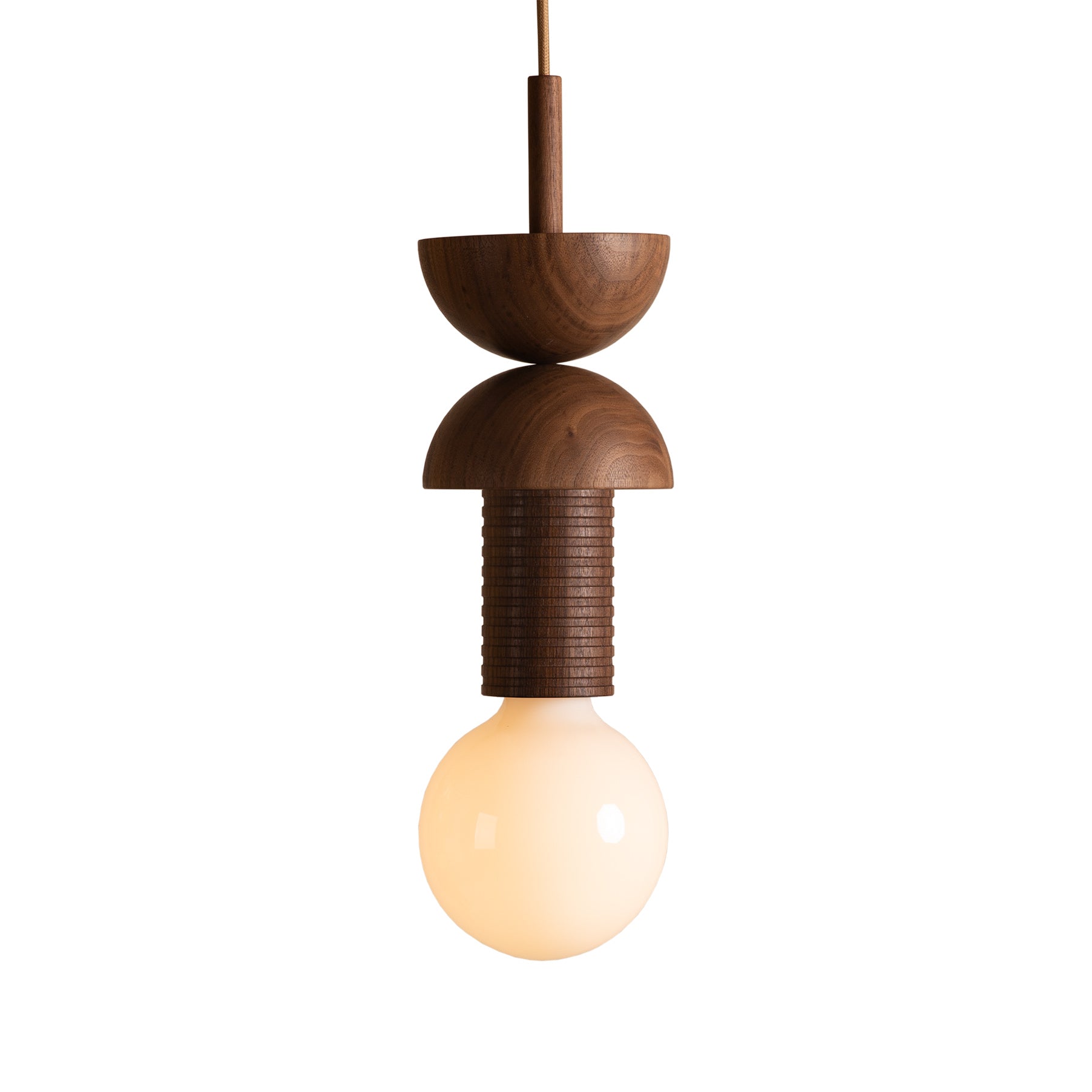 Introducing the Junit Copla by Schneid: a modern pendant light inspired by the Bauhaus movement, featuring a ribbed cylindrical section framed by two smooth, semi-spherical walnut wood pieces and a round bulb that casts a warm glow against its crisp white backdrop.