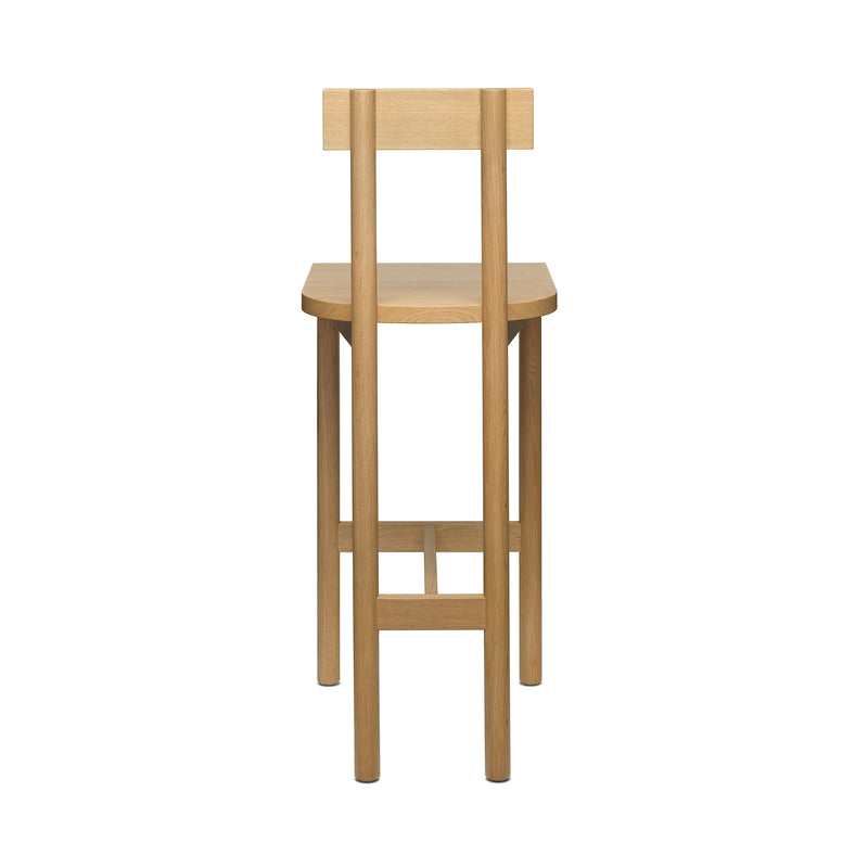 The SX02 GAMAR BARSTOOL by E15 features a minimalist design with a flat backrest, four straight legs, and crafted from European oak. The visible wood grain enhances its natural look while showcasing the elegant backrest and legs.