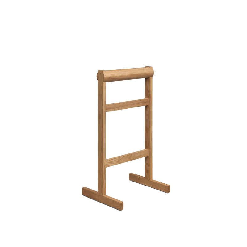 The E15 SX03 GAMAR Wardrobe Stand showcases a simple yet modern rustic design with two horizontal bars on a rectangular frame and base, crafted from light European oak. Its elegantly set against a plain white background.