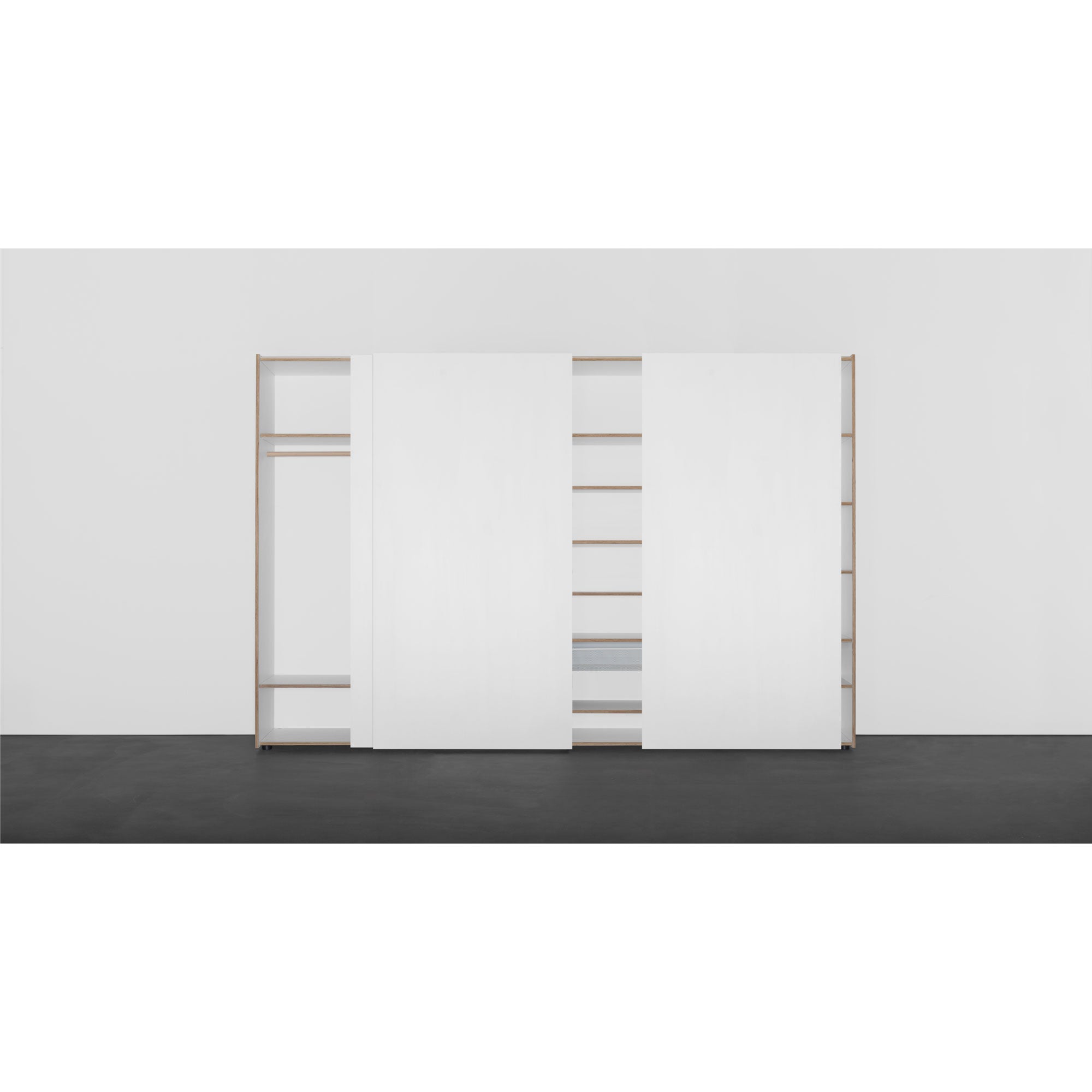 The Kubatur wardrobe by Sanktjohanser is a minimalist wooden piece with sleek white sliding doors that open to customizable shelves, set against a light gray backdrop with dark flooring for a seamless look.