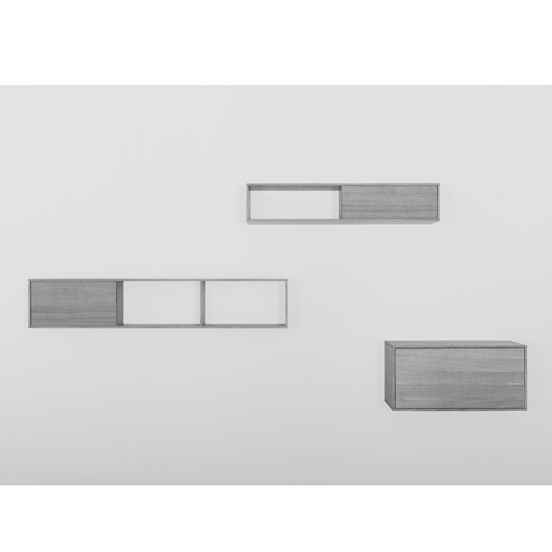 The Sanktjohanser Tektur sideboard features minimalist wall-mounted shelving with three rectangular units in light gray oak veneer. Two shelves offer open and closed sections with sliding doors, while the third is fully enclosed, providing a stylish and functional customizable shelf system.