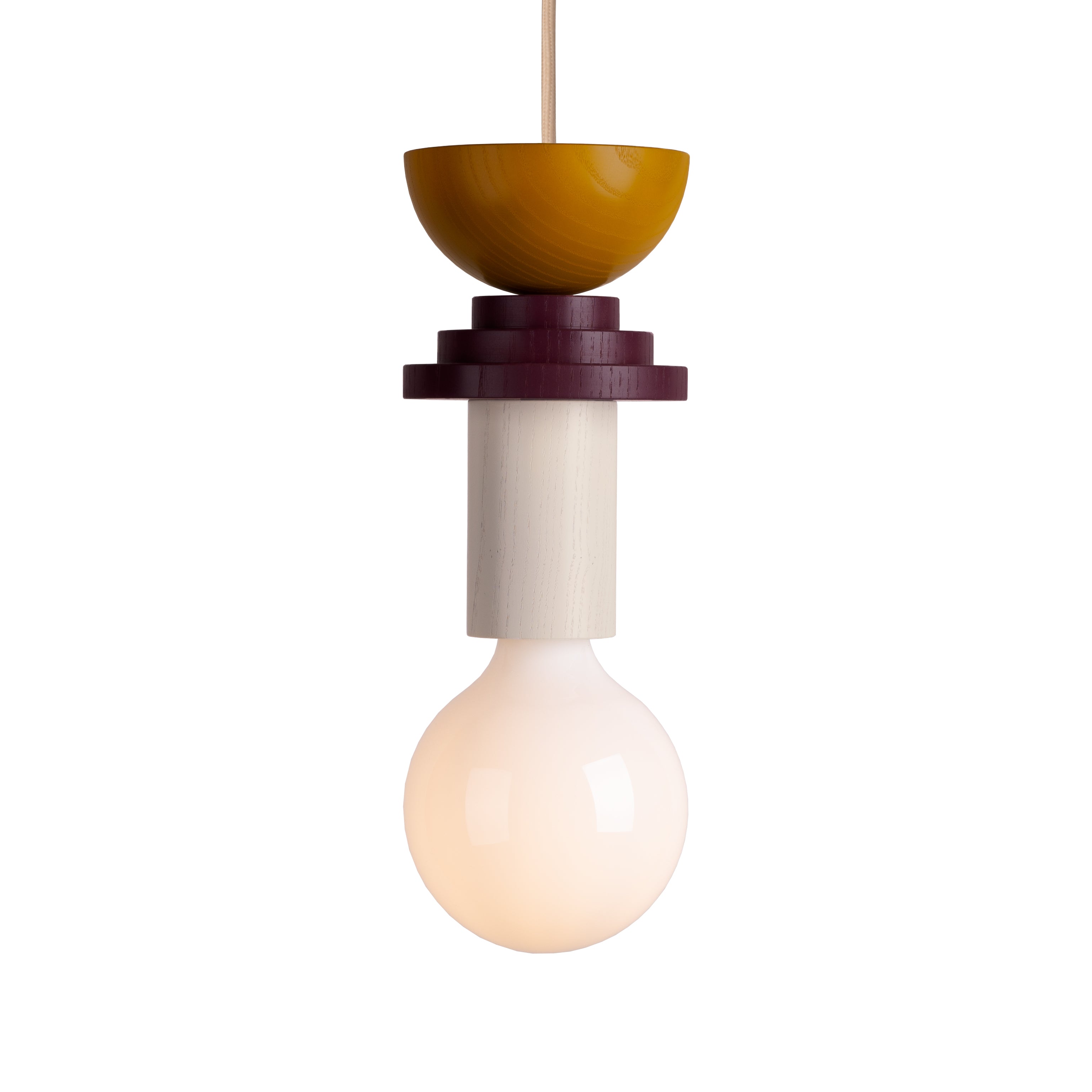 The Junit Karma by Schneid is a modern modular pendant lamp boasting a unique design with a round bulb and geometric, layered fixture in yellow, maroon, and cream. It hangs elegantly from a thin cord.
