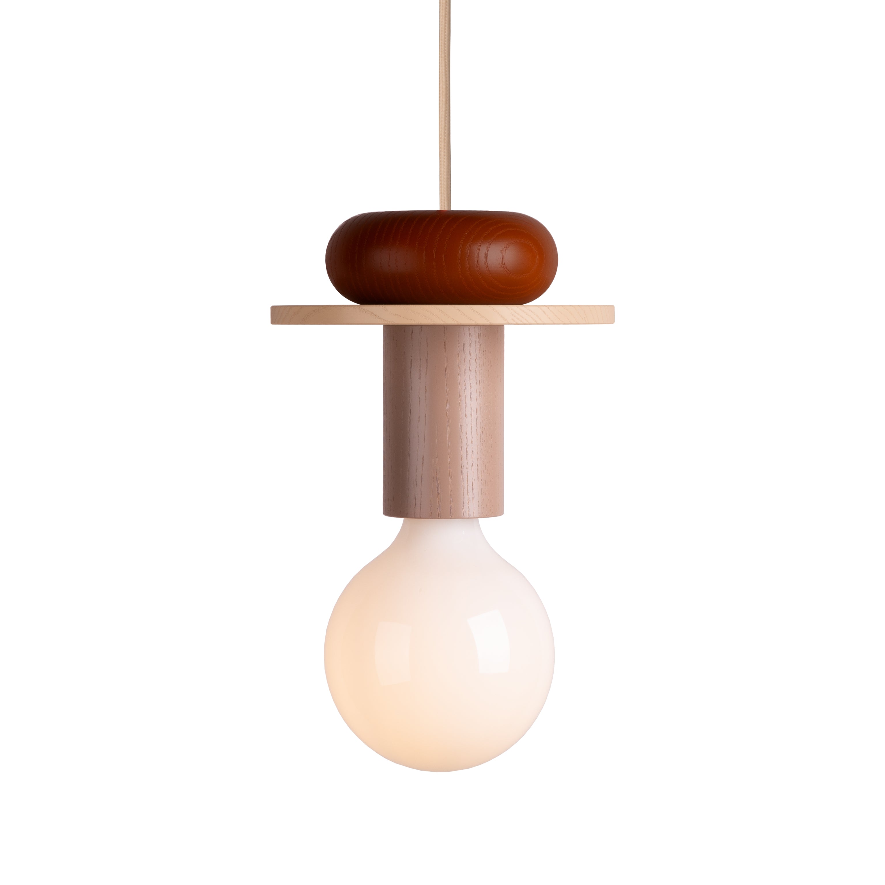 The Schneid Junit Pan is a modern modular pendant lamp featuring a minimalist design with a large round white bulb beneath an ash wood cylindrical fixture, topped with a circular reddish-brown accent and suspended by a thin cord to cast ambient light.
