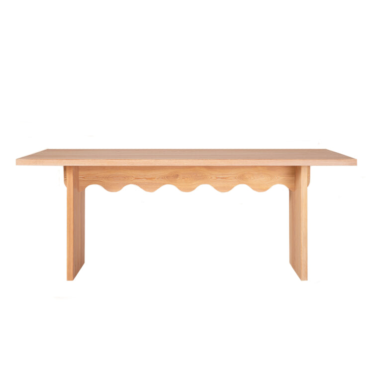 The Tami Table by Schneid, part of their Tami Dining Collection, features a flat rectangular top with a unique scalloped apron design. Its straight legs provide a minimalist elegance. Crafted from naturally oiled larch wood, it boasts a light, natural finish.
