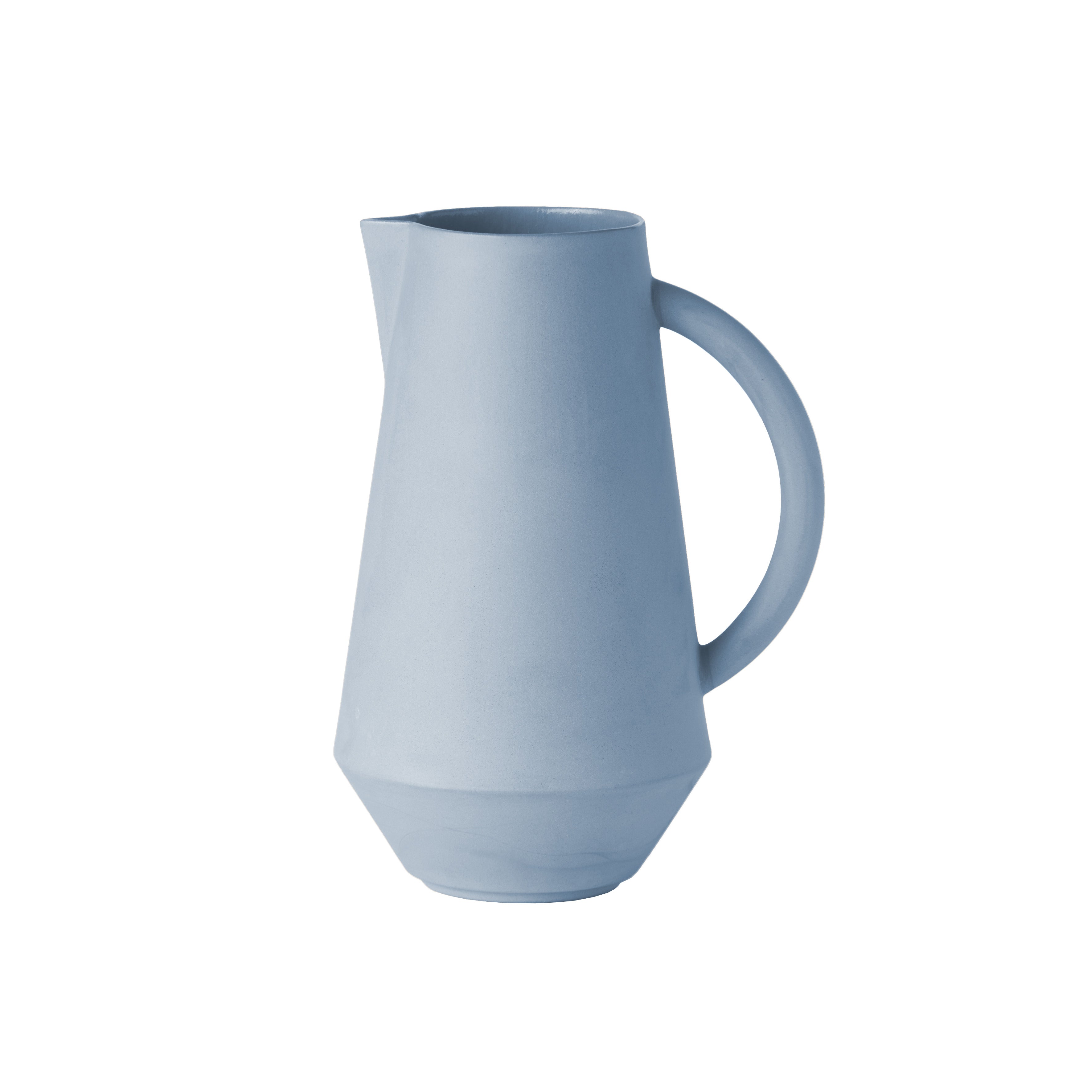 The Unison Carafe by Schneid is a modern, light blue ceramic pitcher with a sleek geometric design, handcrafted in Germany. It features a wide base, narrow neck, and generously curved handle against a white backdrop.