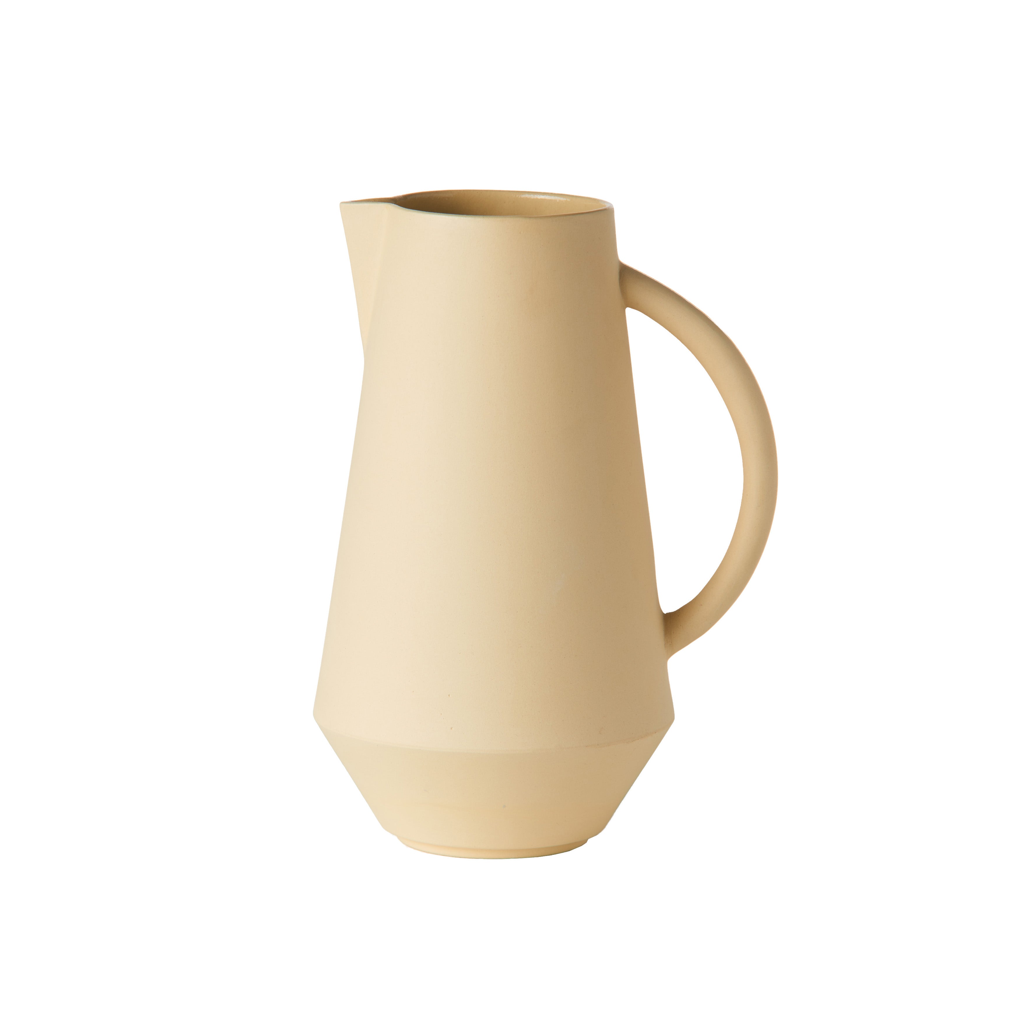 The Unison Carafe by Schneid is a cream-colored ceramic pitcher with a matte finish. It possesses a wide, angled body, narrow spout, and curved handle. Handcrafted in Germany, its minimalist design enhances a modern aesthetic against the white background.